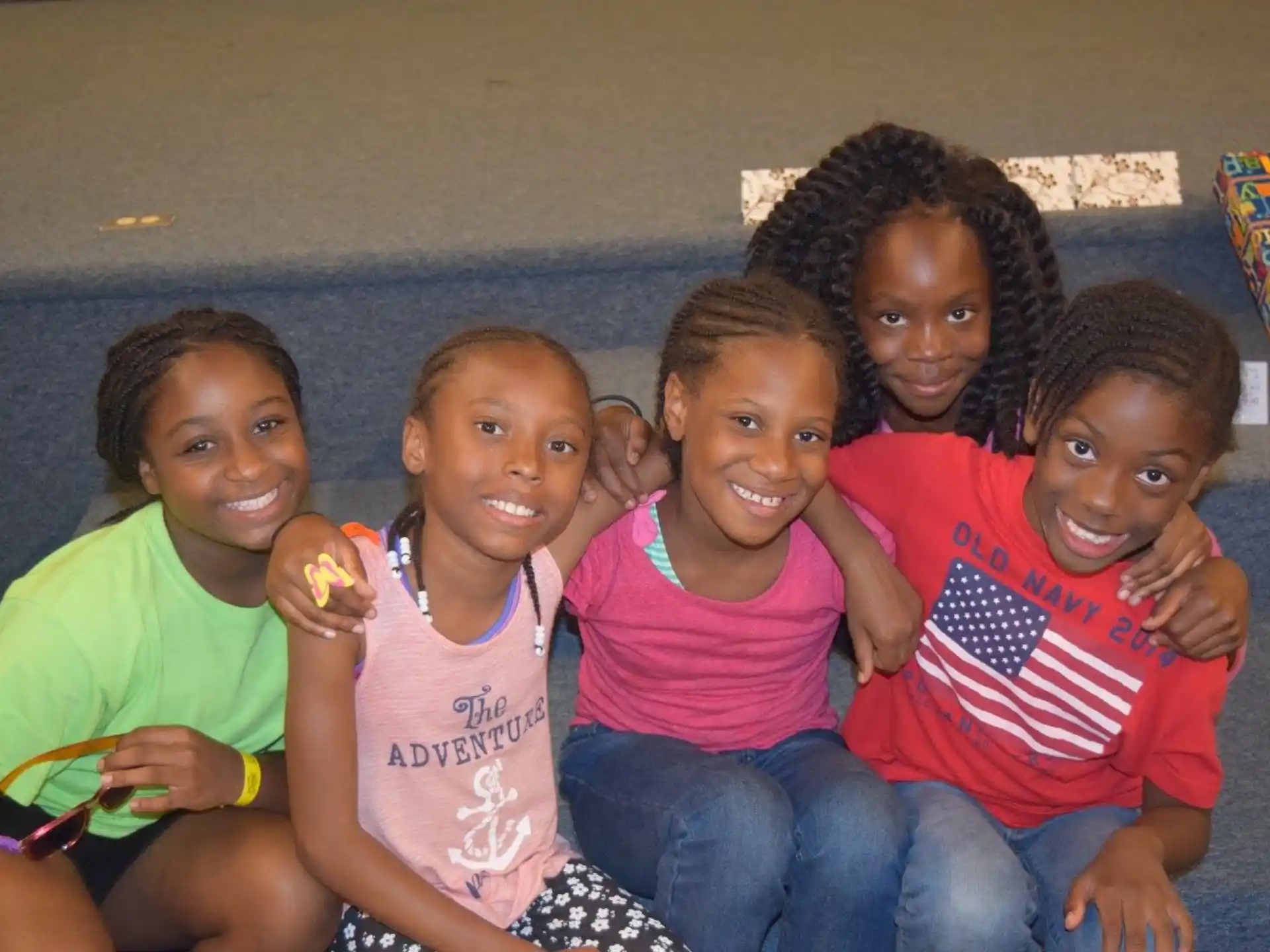 a group of children sitting together smiling