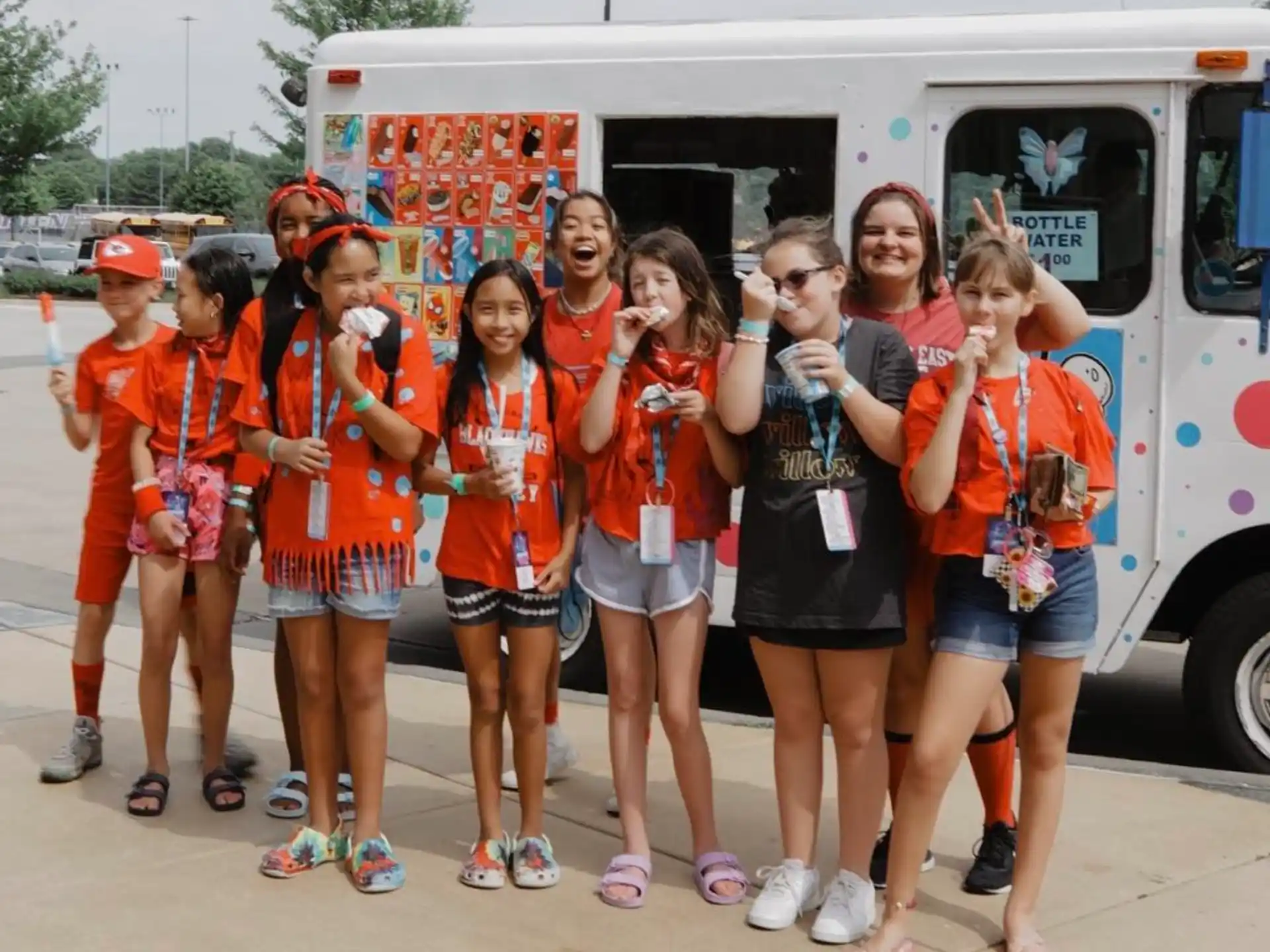 a group of girls posing for a photo in front of a food truck