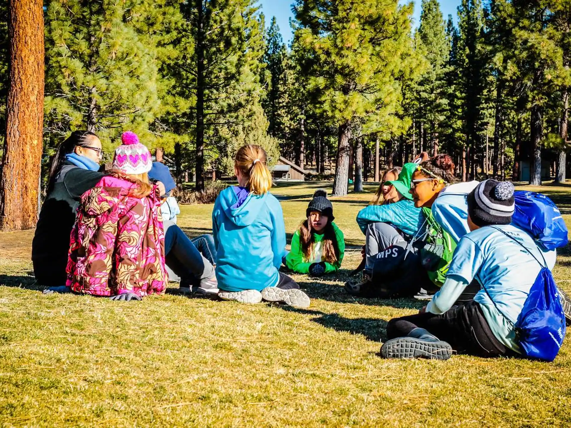 a group of people sitting on the ground outside