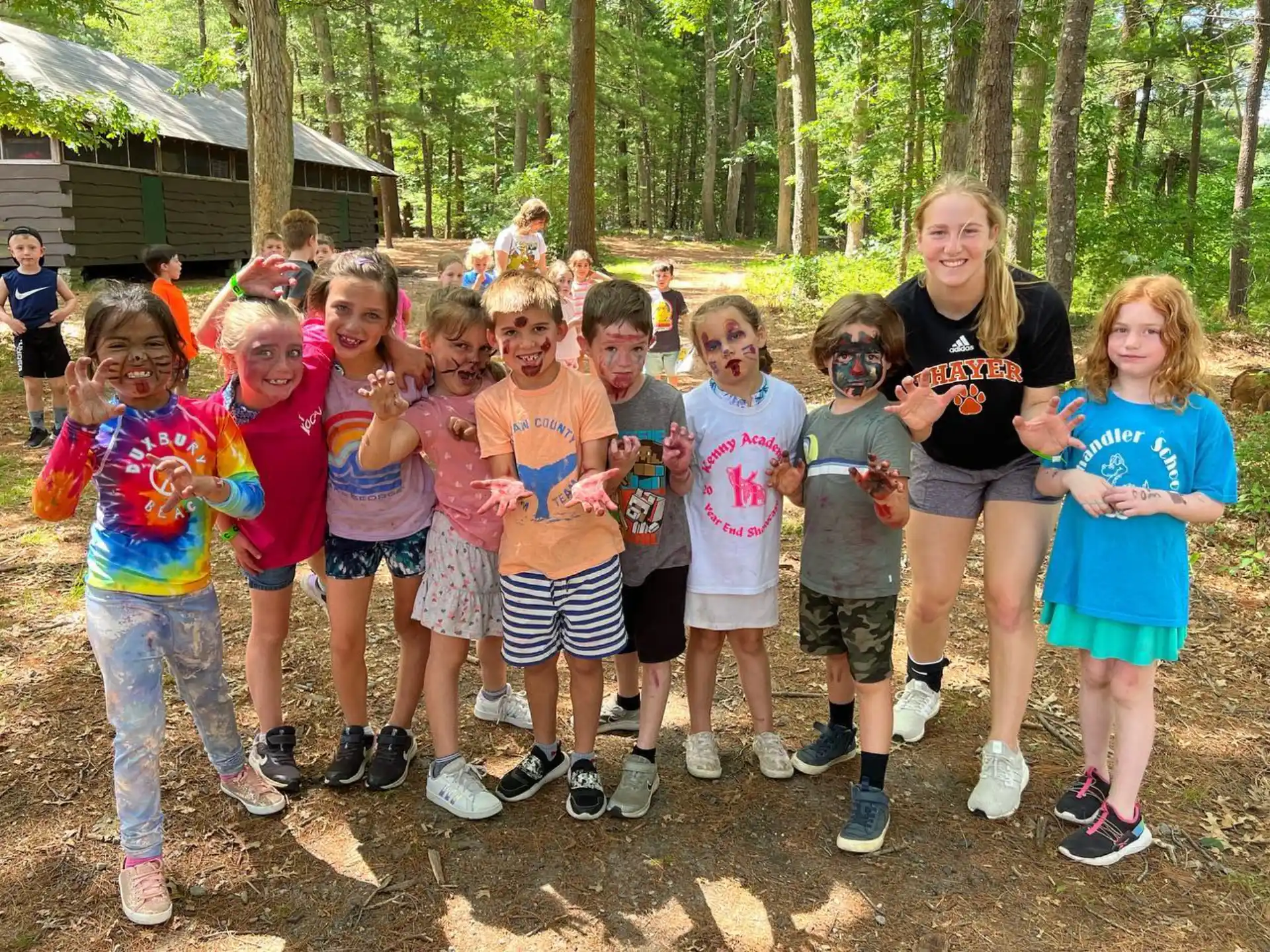 a group of children posing for a photo in the woods