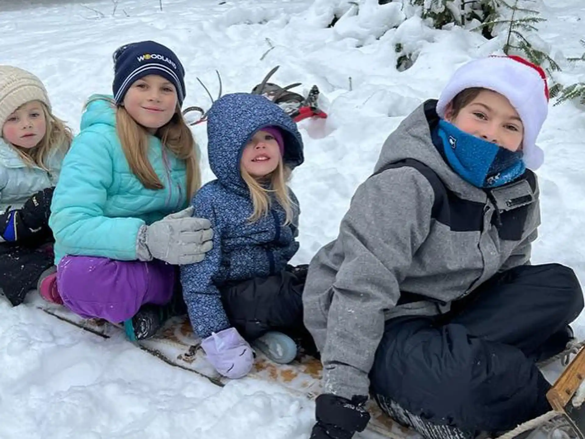 a group of children sitting in the snow