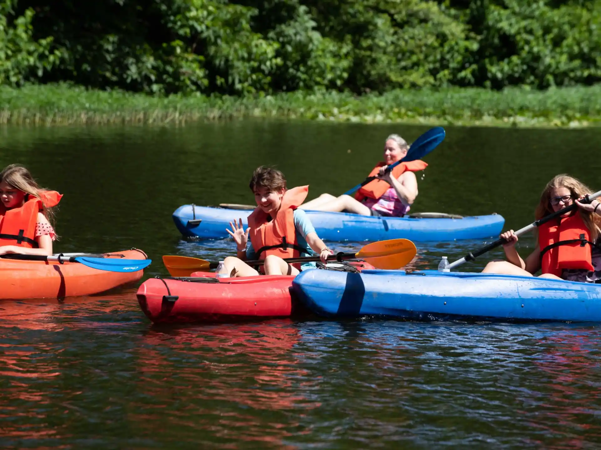 a group of kids in kayaks