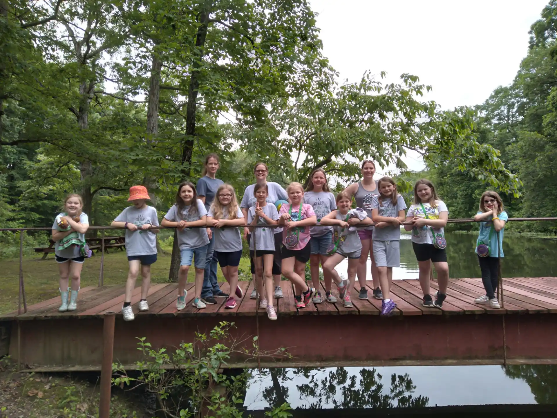 a group of people posing on a wooden bridge