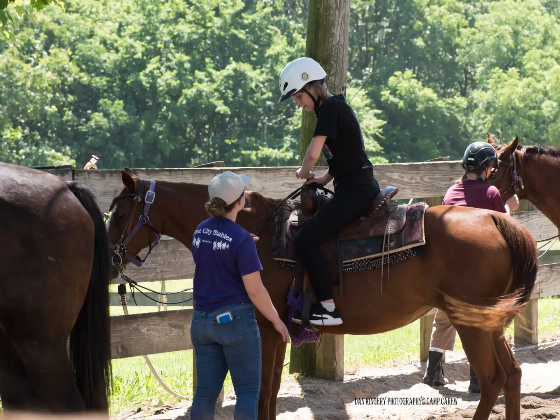 a group of people stand around some horses