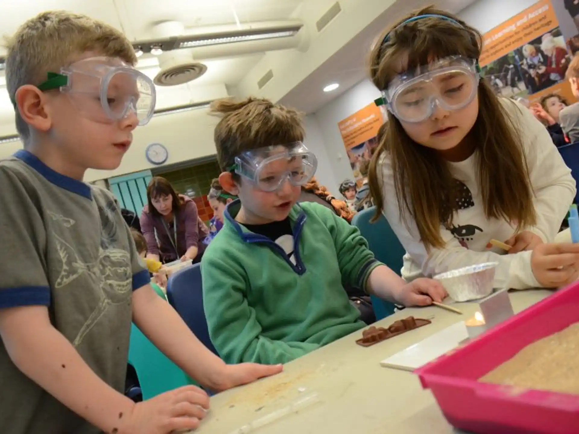 a group of people wearing safety goggles and looking at a piece of paper