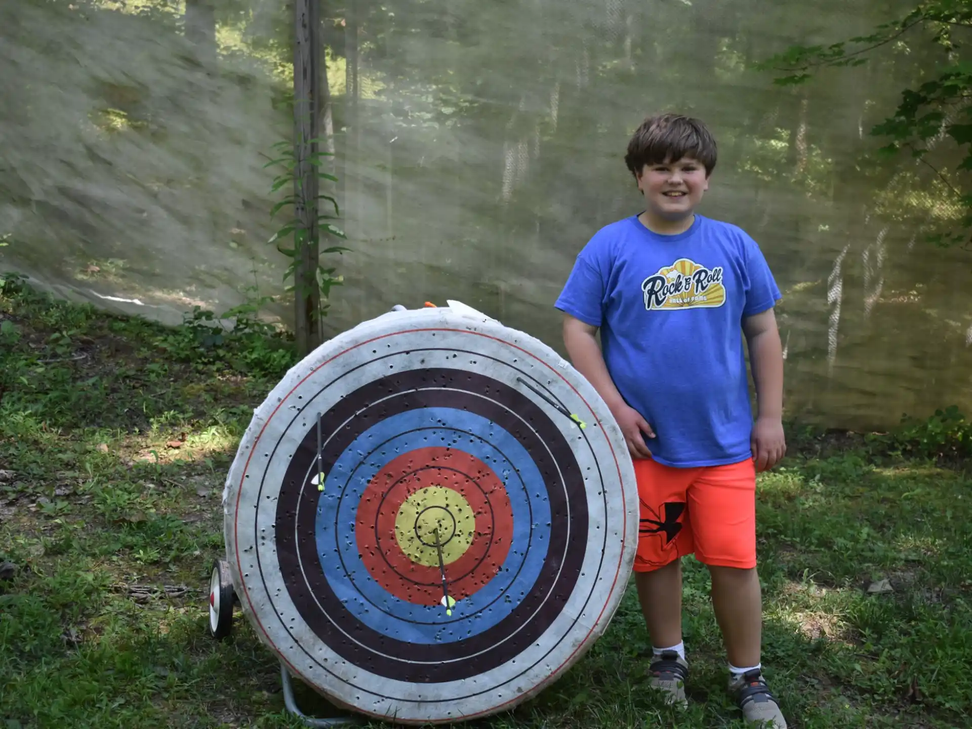a boy standing next to a large tire