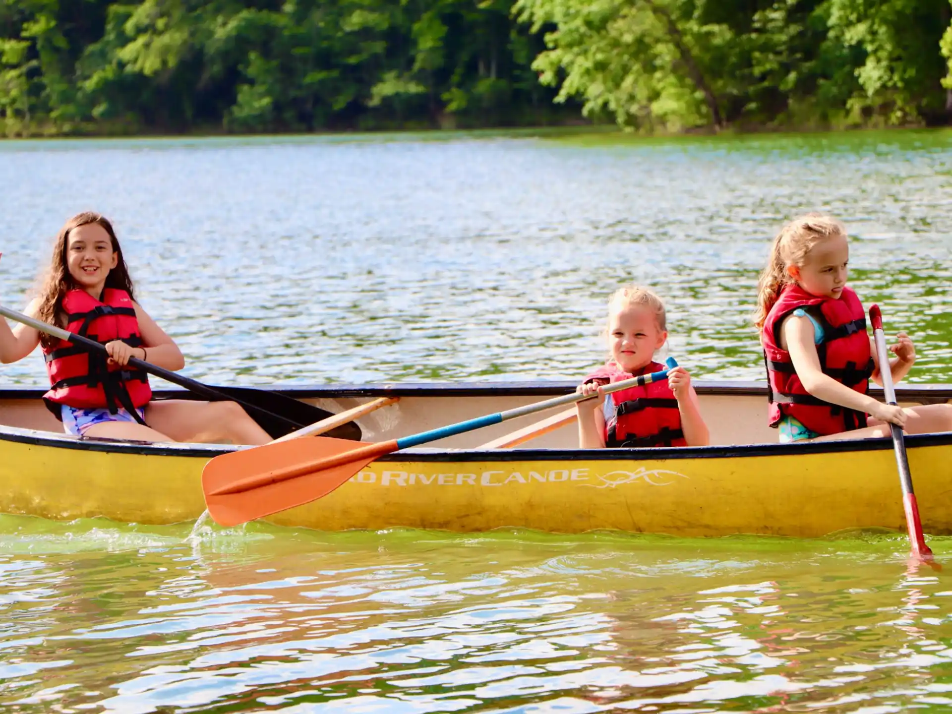 a group of kids in a canoe