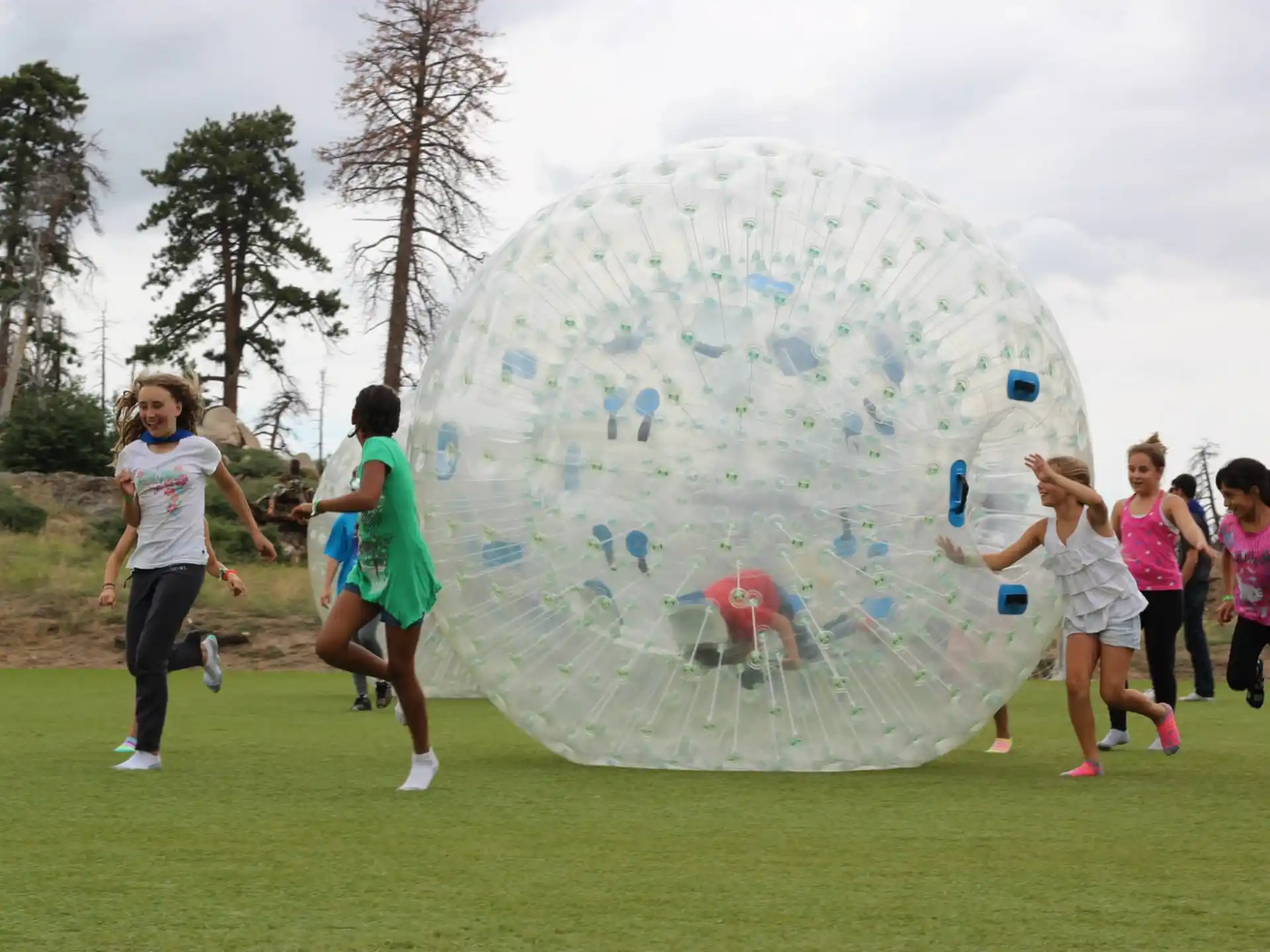 a group of people running around a large bubble