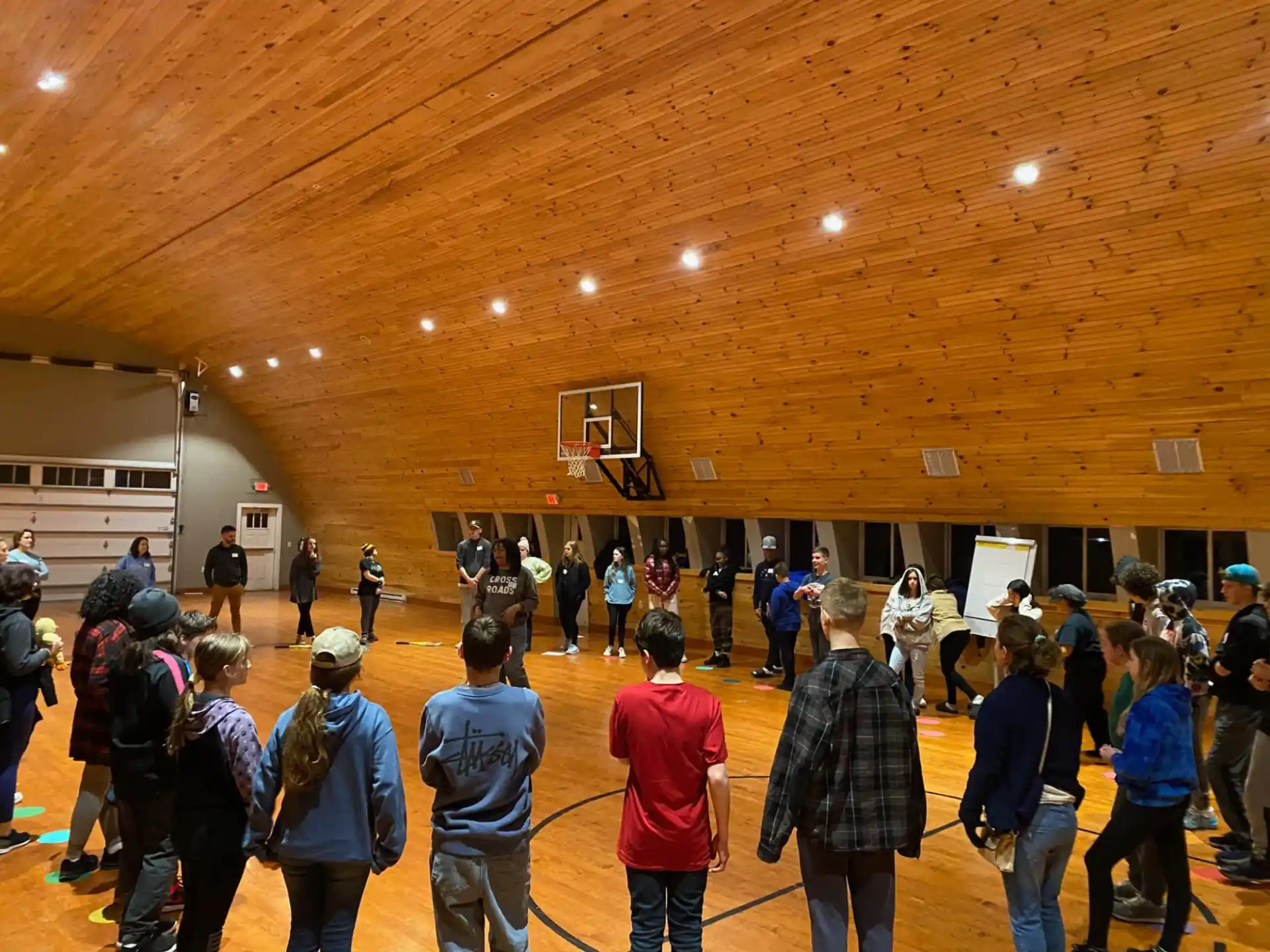 a group of people in a large room with a wood ceiling