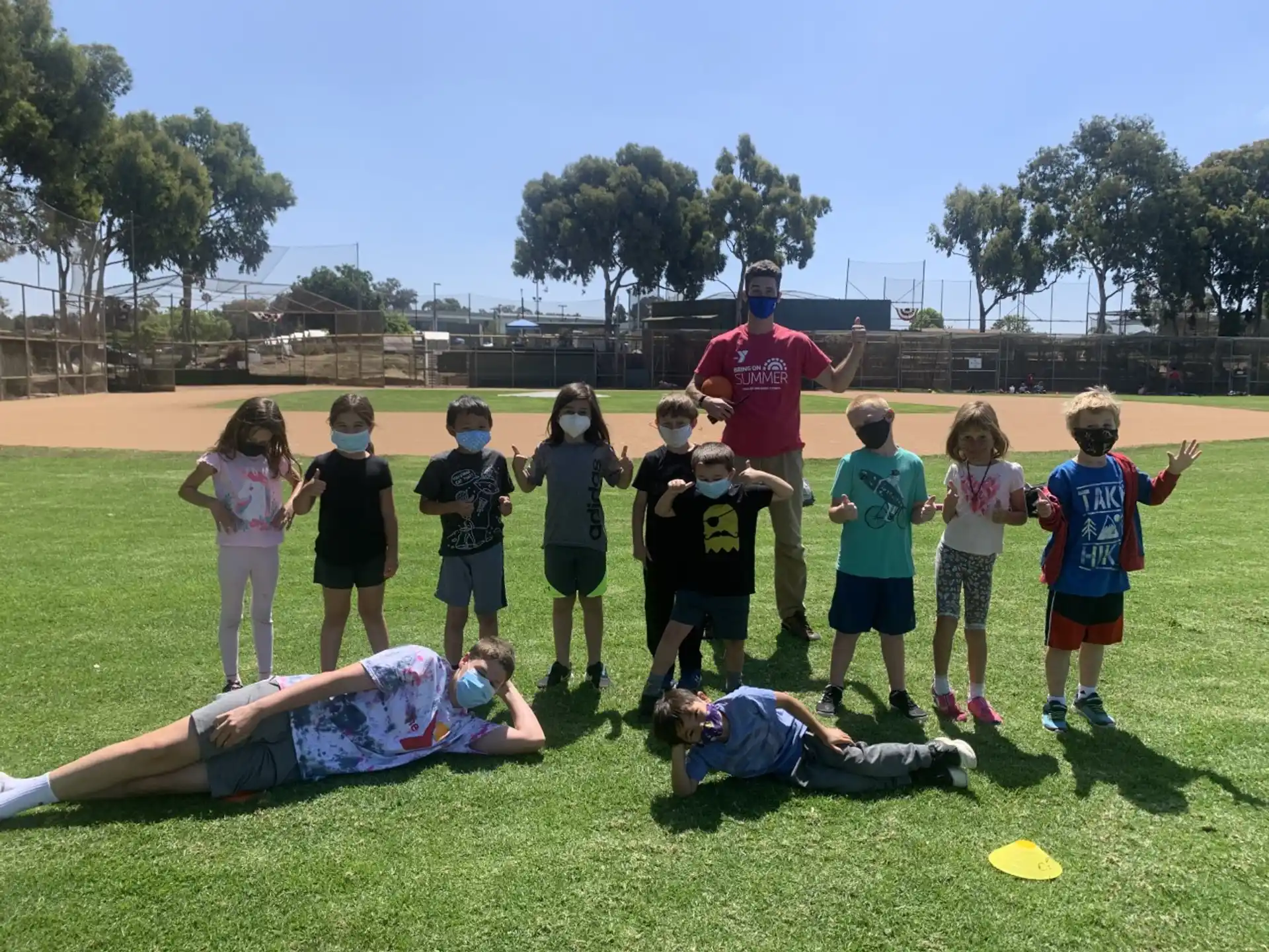 a group of kids playing with a man and woman