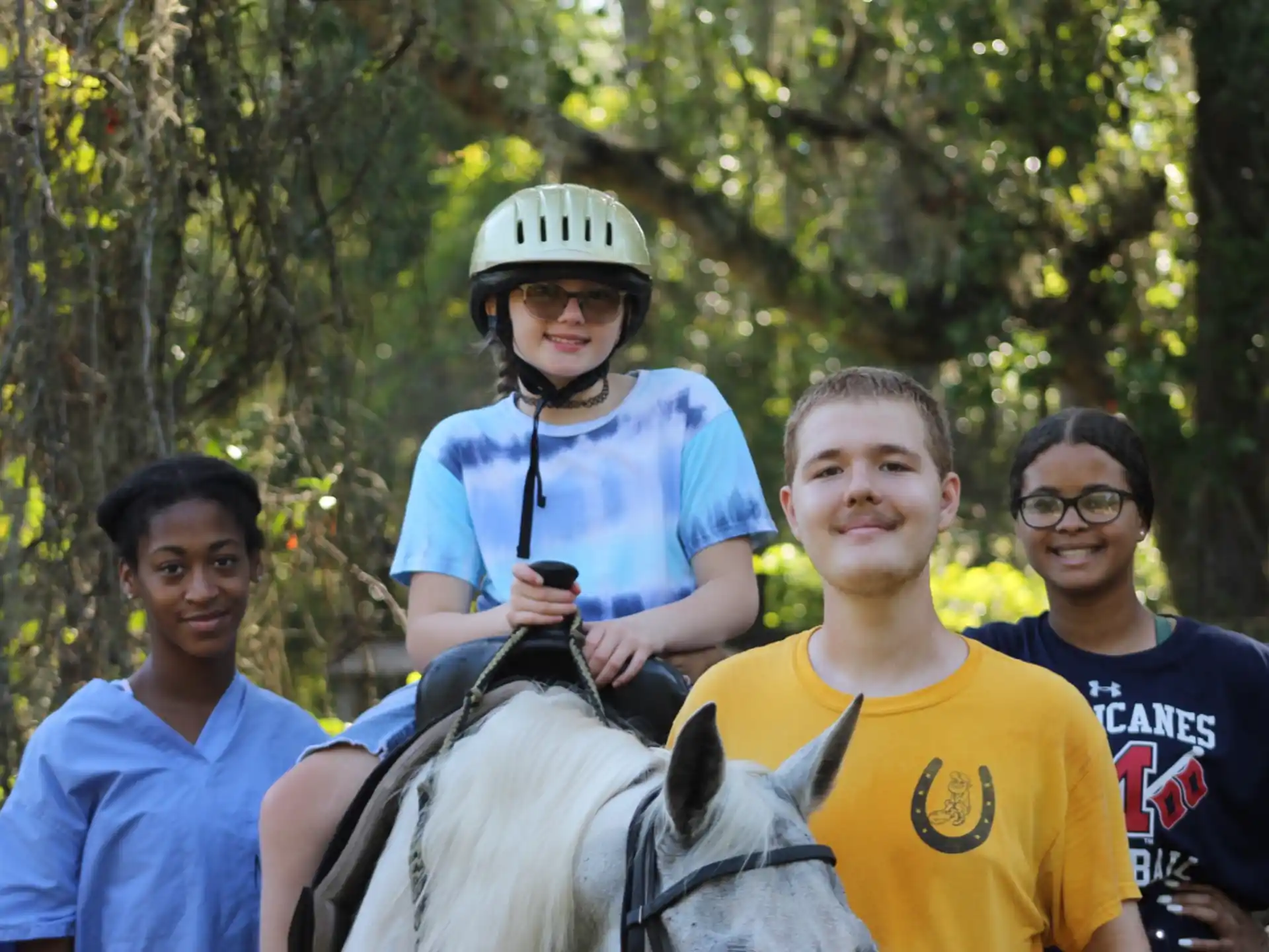 a group of people posing for a photo with a person on a horse