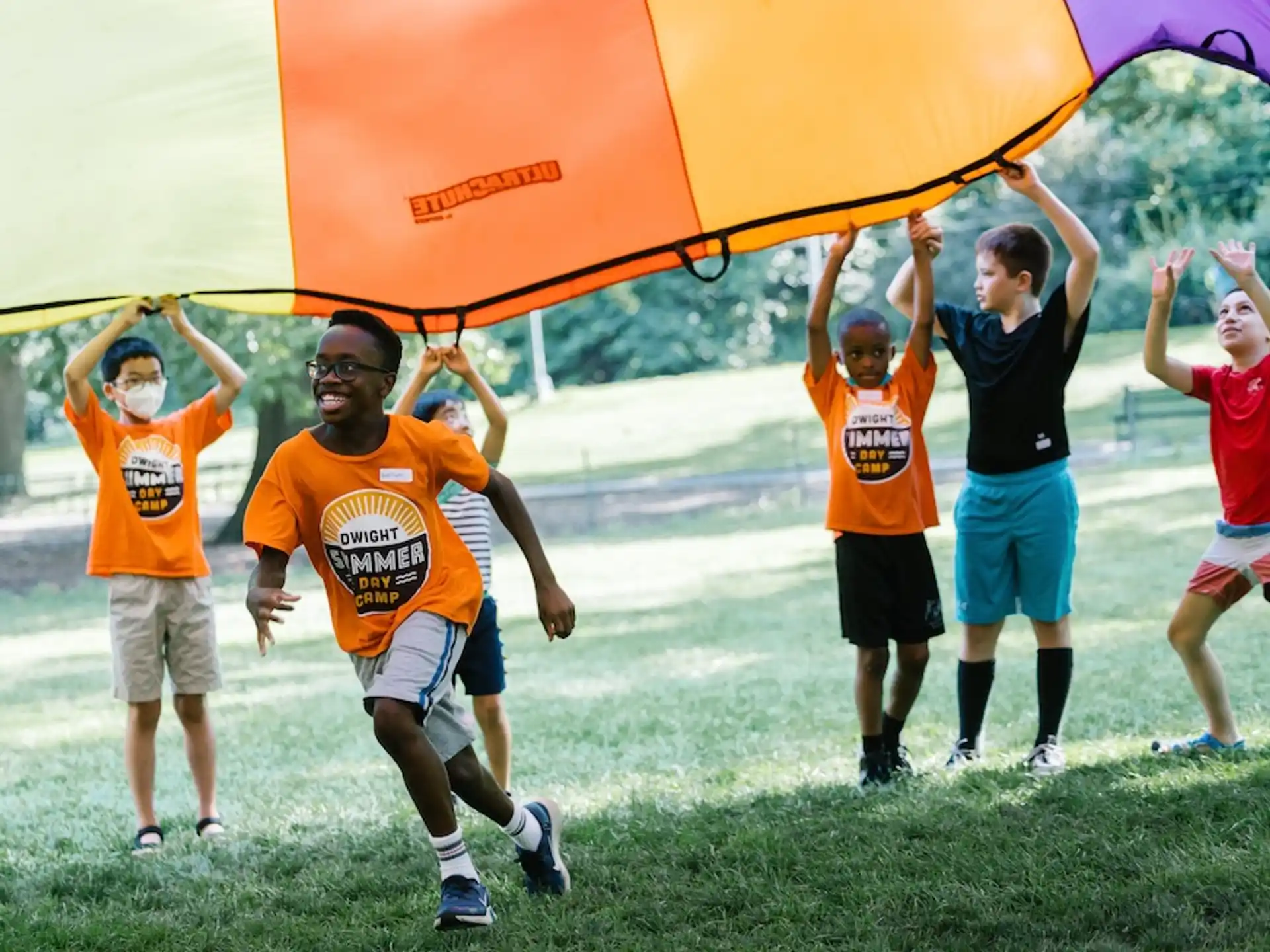a group of people holding a large orange and yellow flag