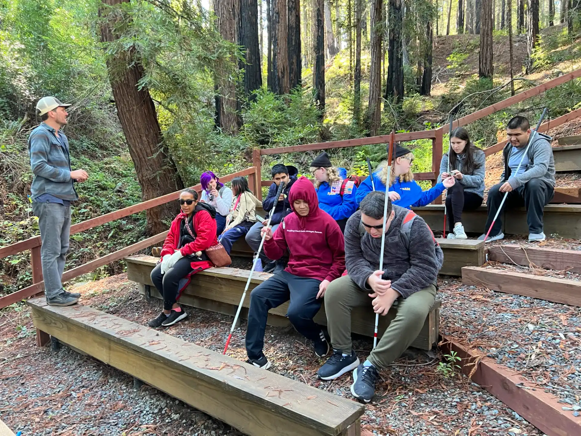 a group of people sitting on a wooden bridge