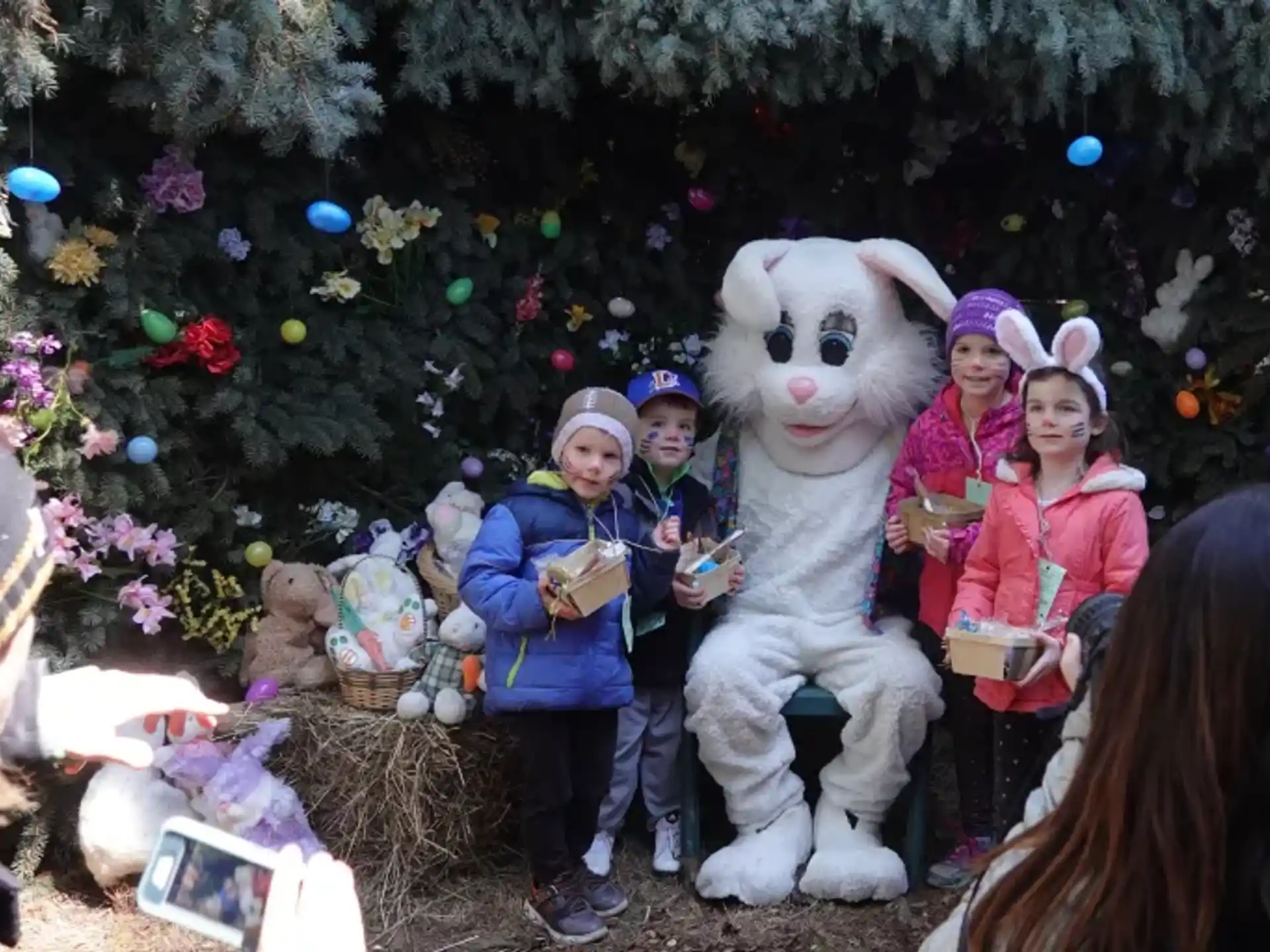 a group of children posing with a person in a rabbit garment