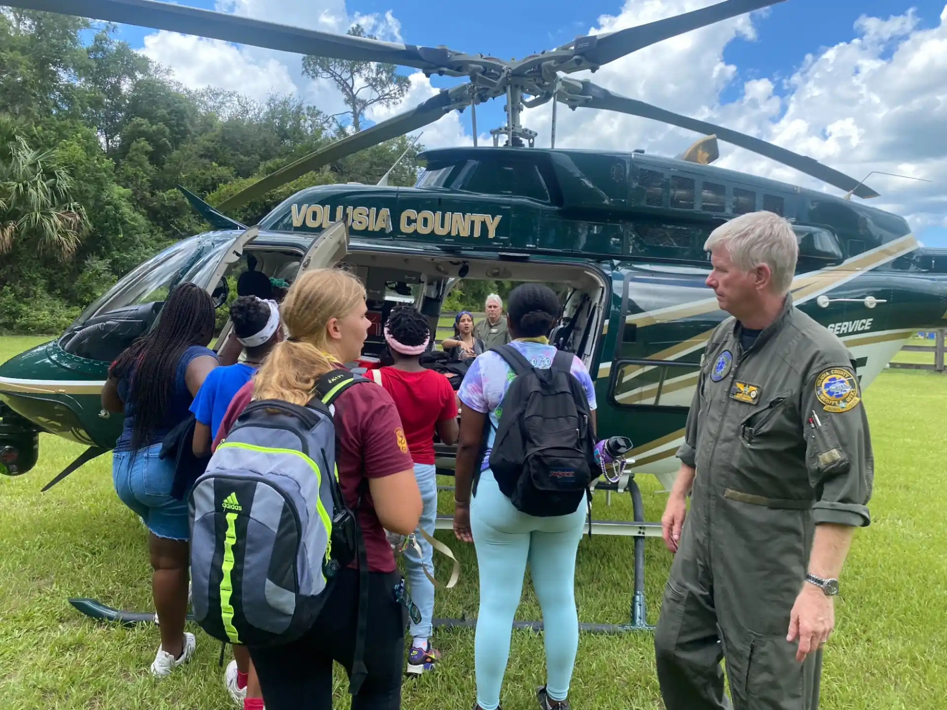 a group of people standing next to a helicopter