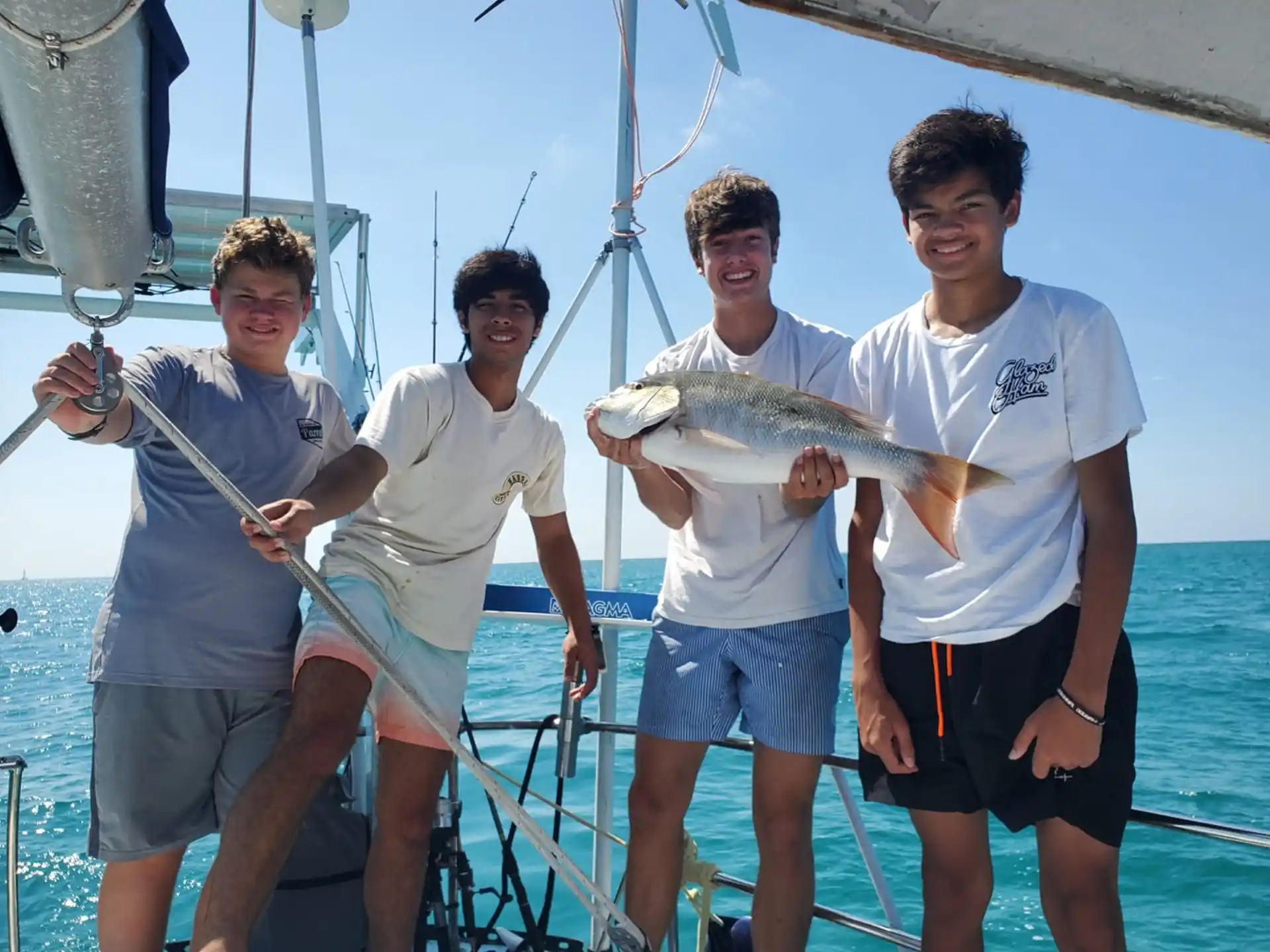 a group of men holding fish on a boat