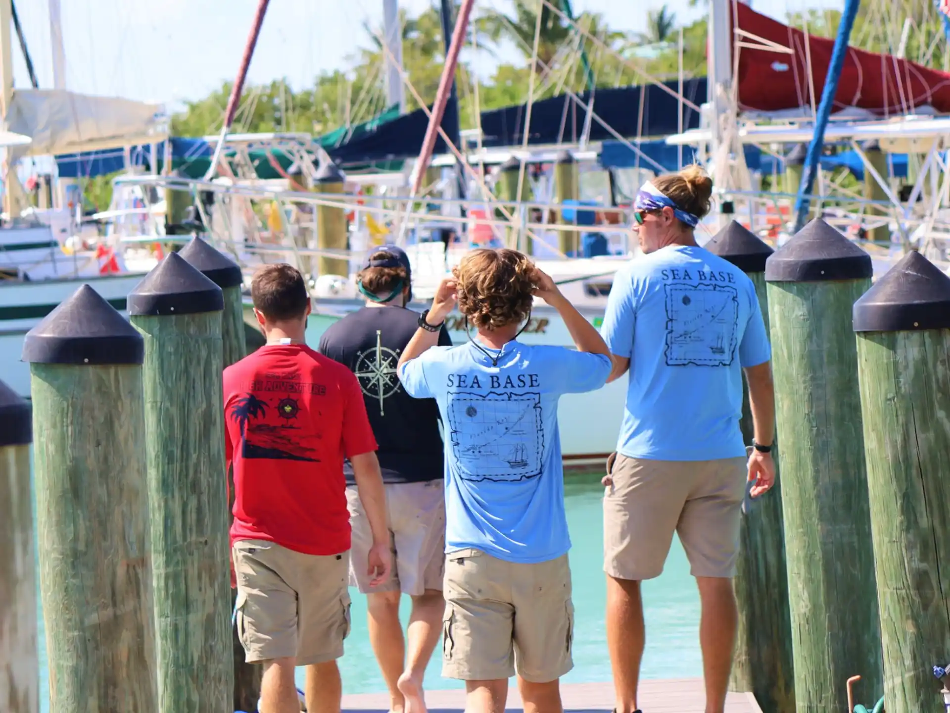 a group of people standing on a dock by a boat