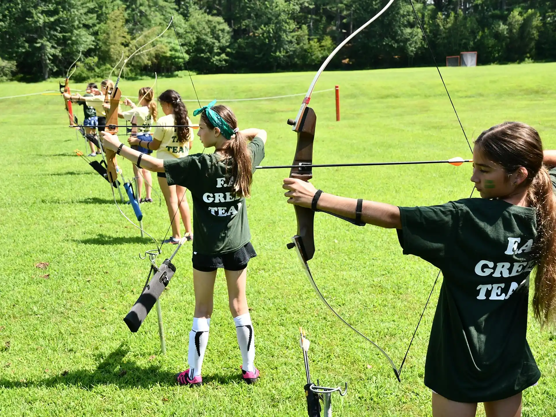 a group of girls playing archery
