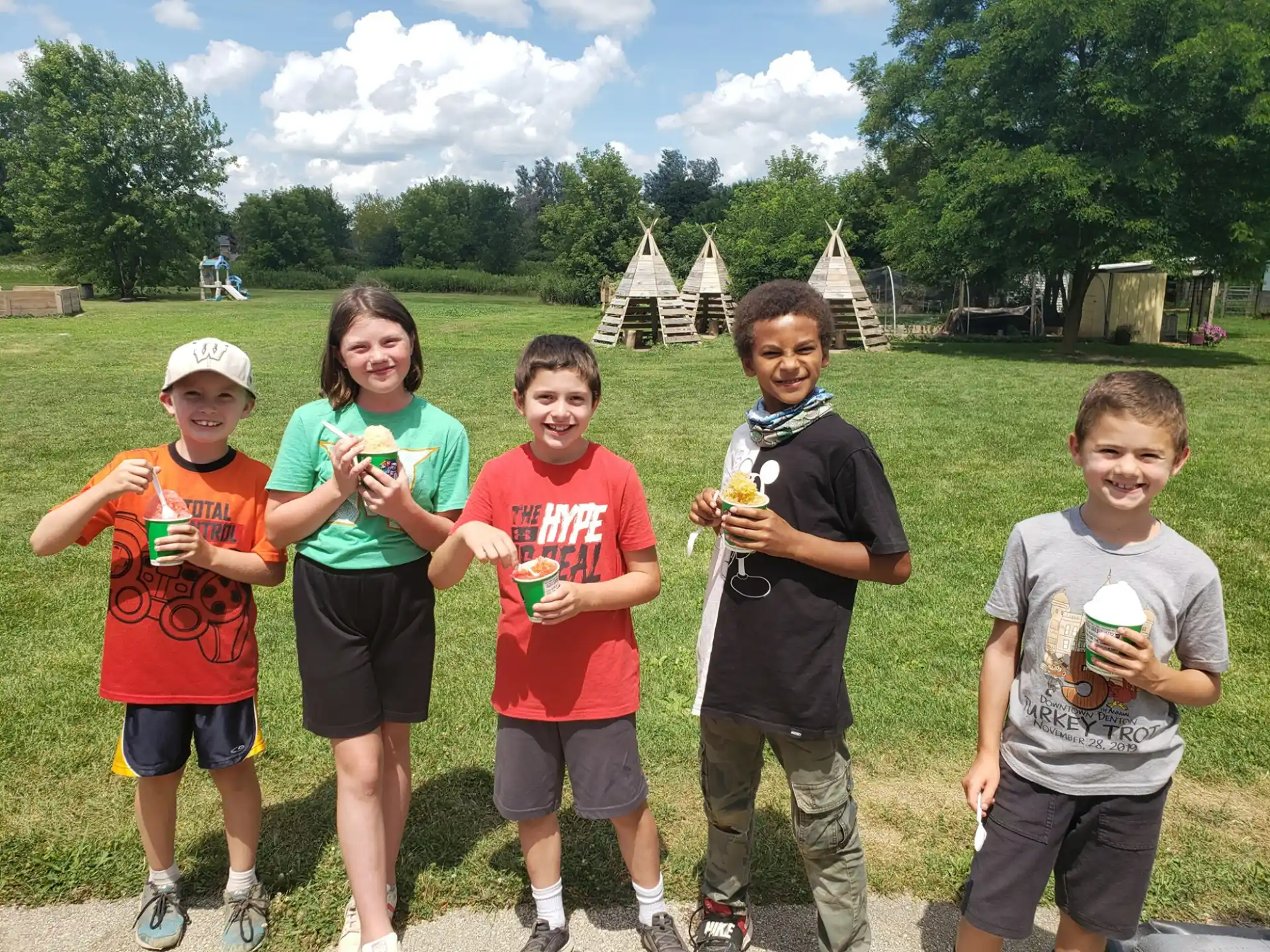 a group of kids holding cups of ice cream
