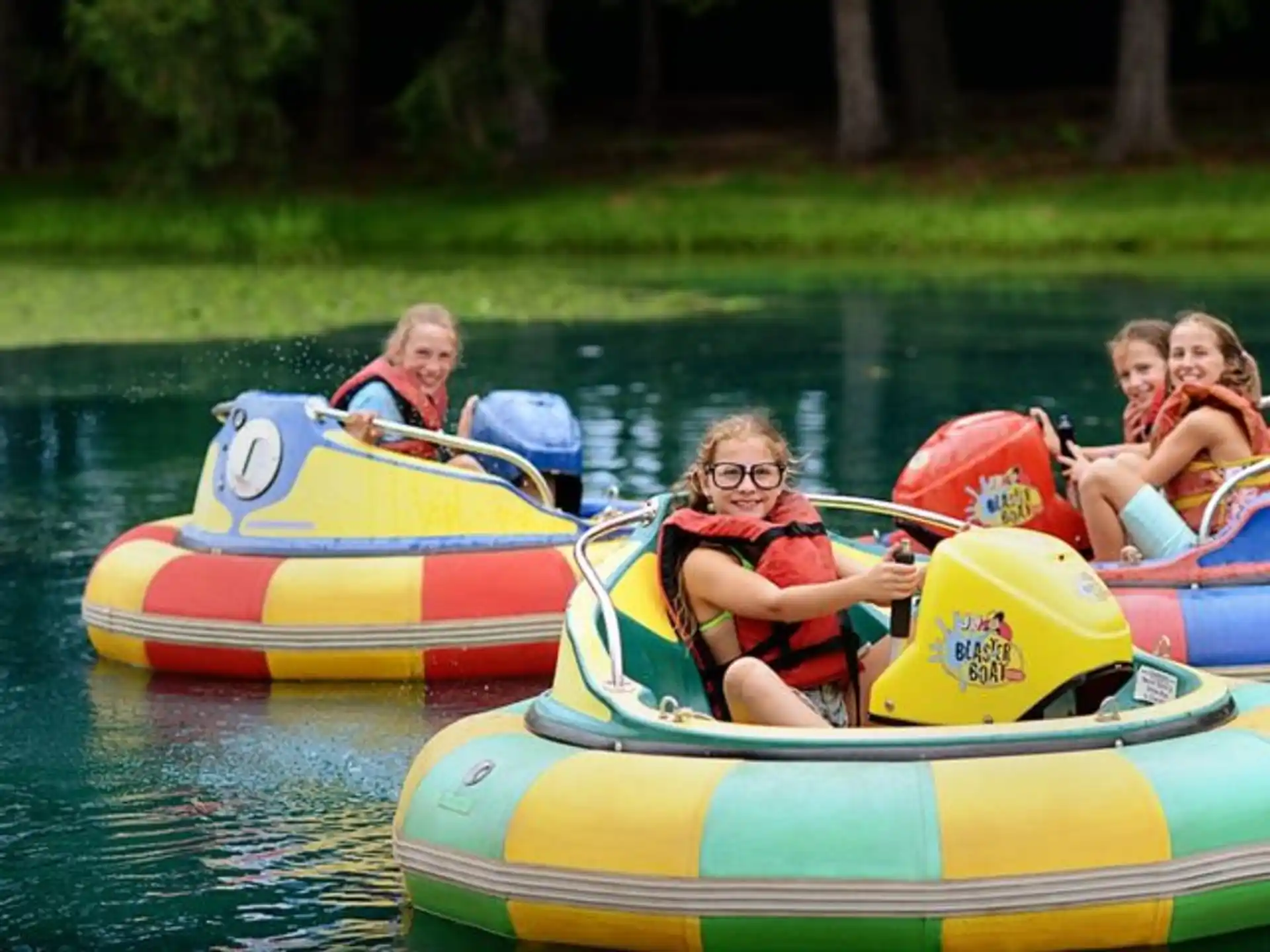 a group of children in inner tubes on a river