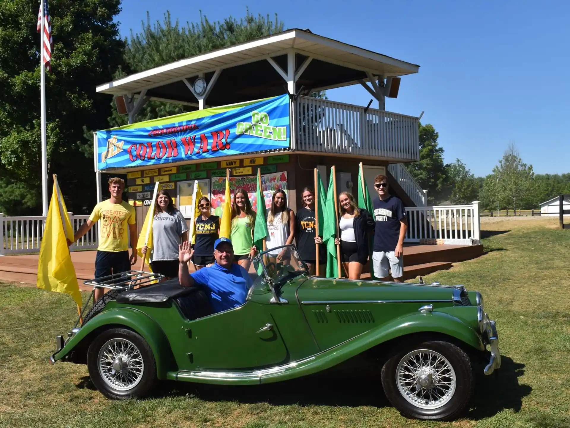 a group of people standing in a small green vehicle with a canopy