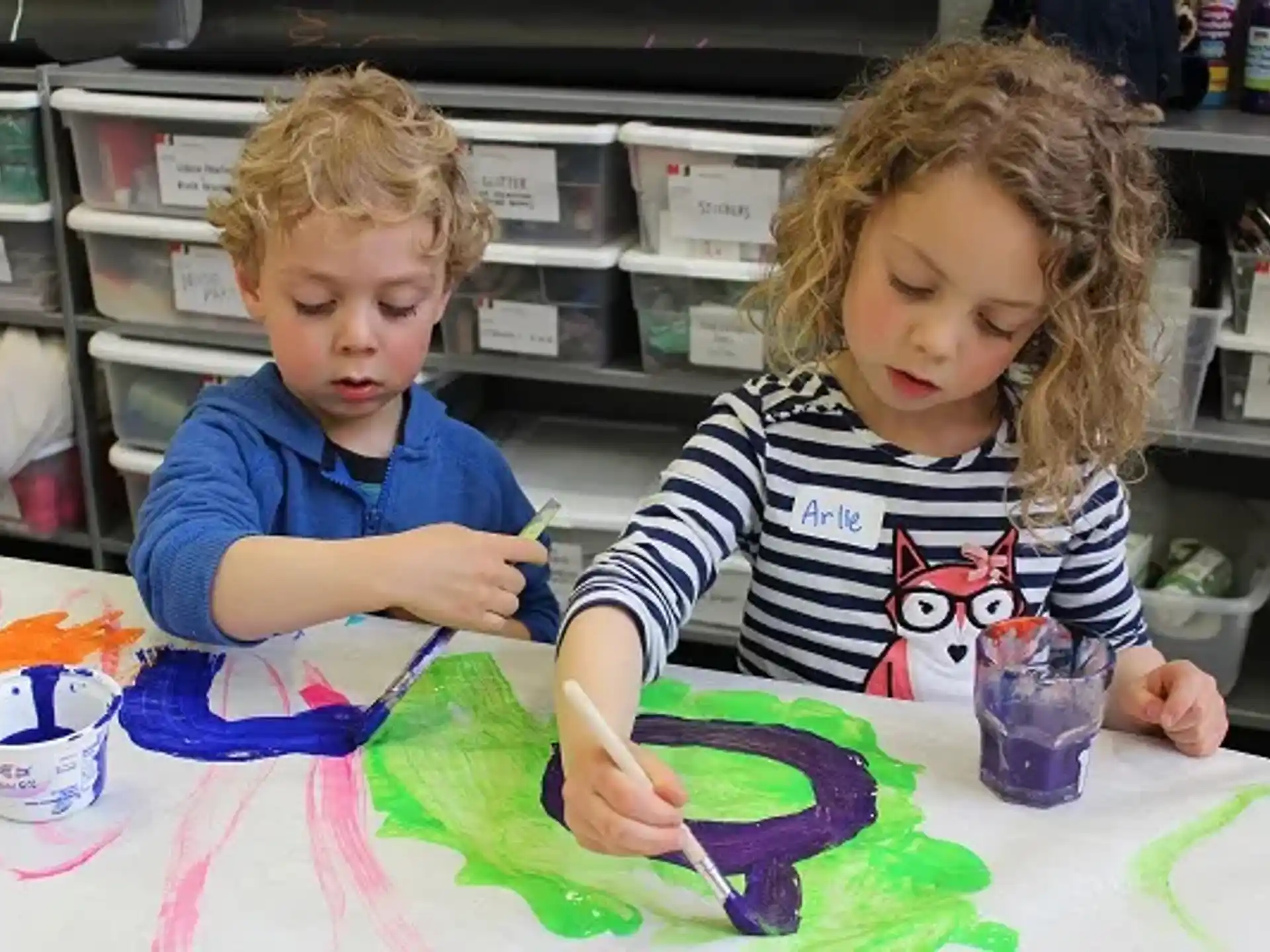 a couple of children painting