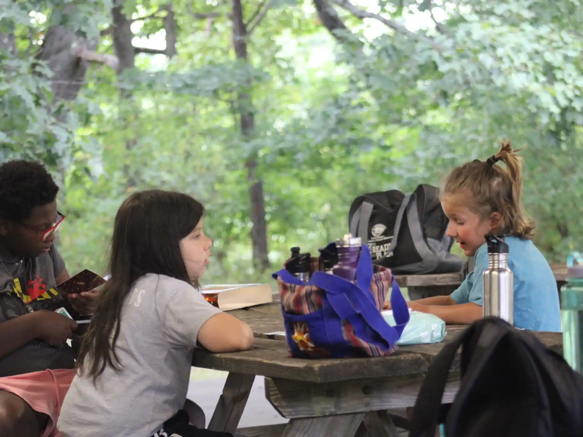 a group of people sitting at a table outside