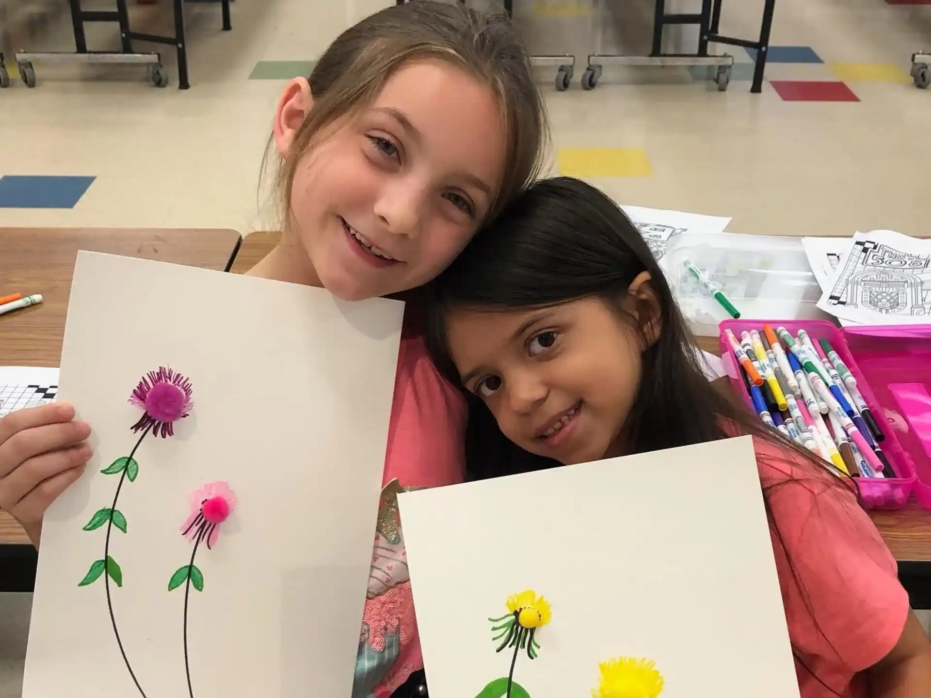 a couple of girls holding a piece of paper