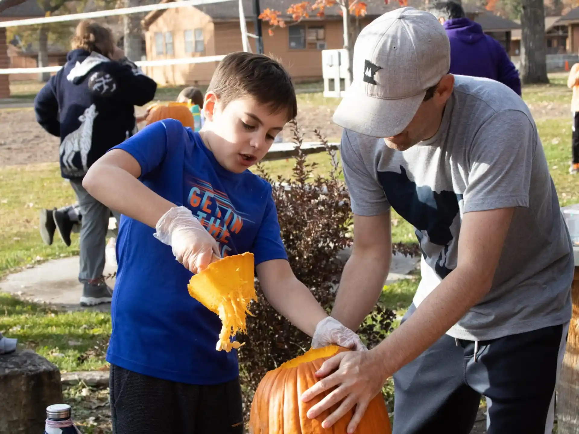 a boy holding a pumpkin and a person holding a pumpkin