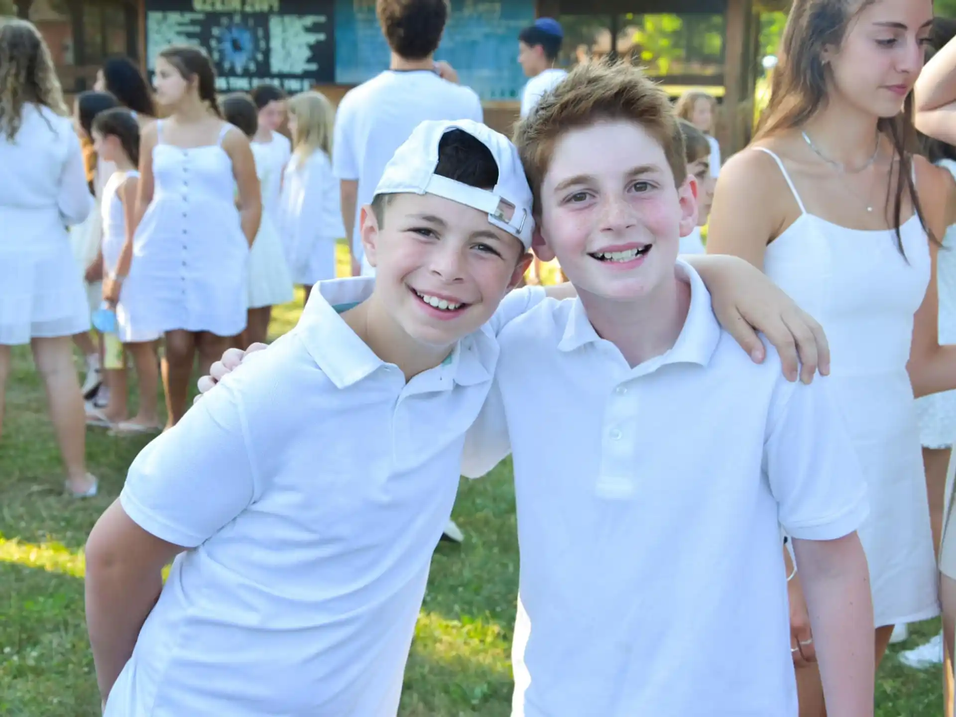a couple of boys posing for a picture in front of a crowd