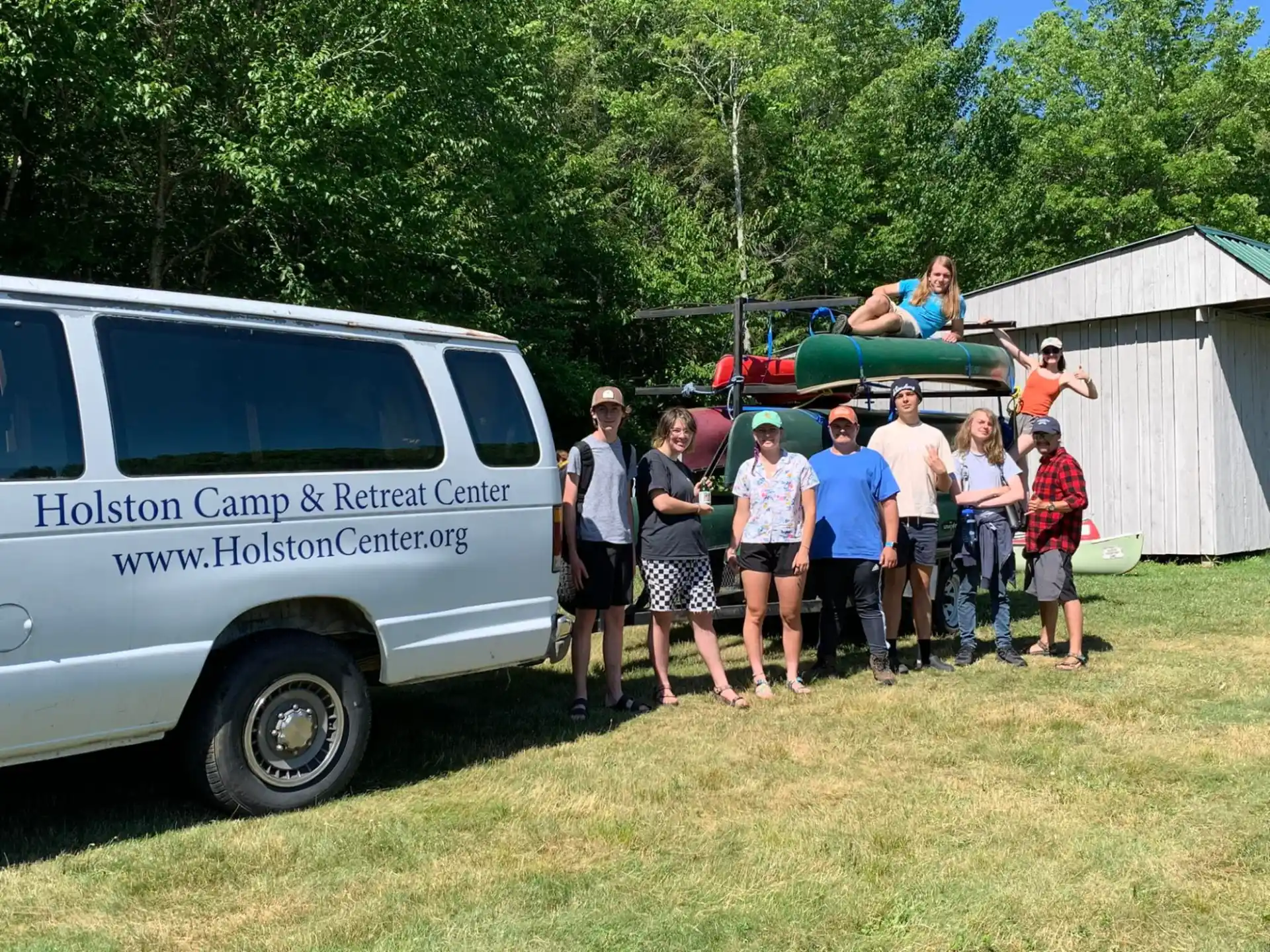 a group of people standing next to a van