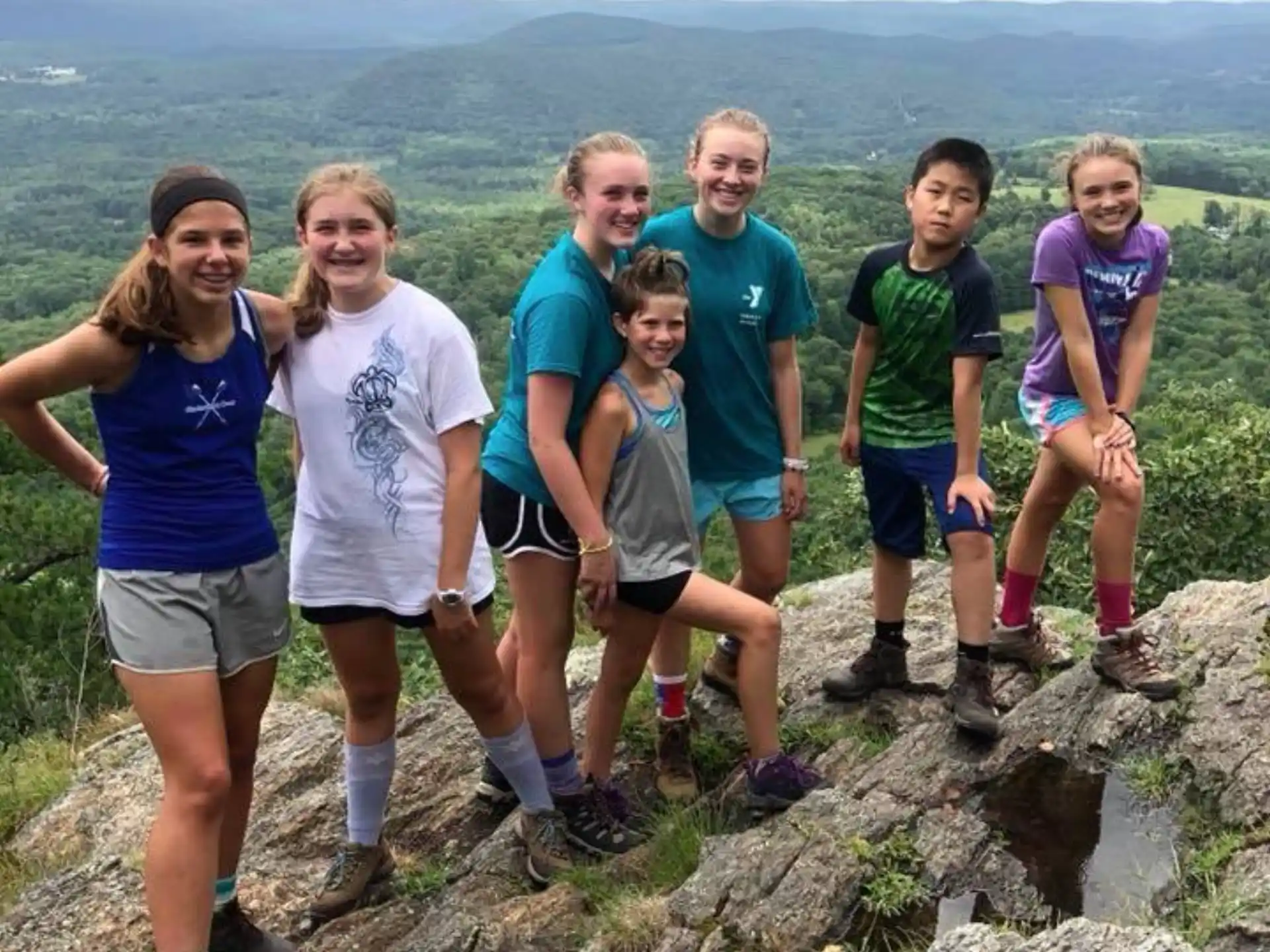 a group of people posing for a photo on a mountain