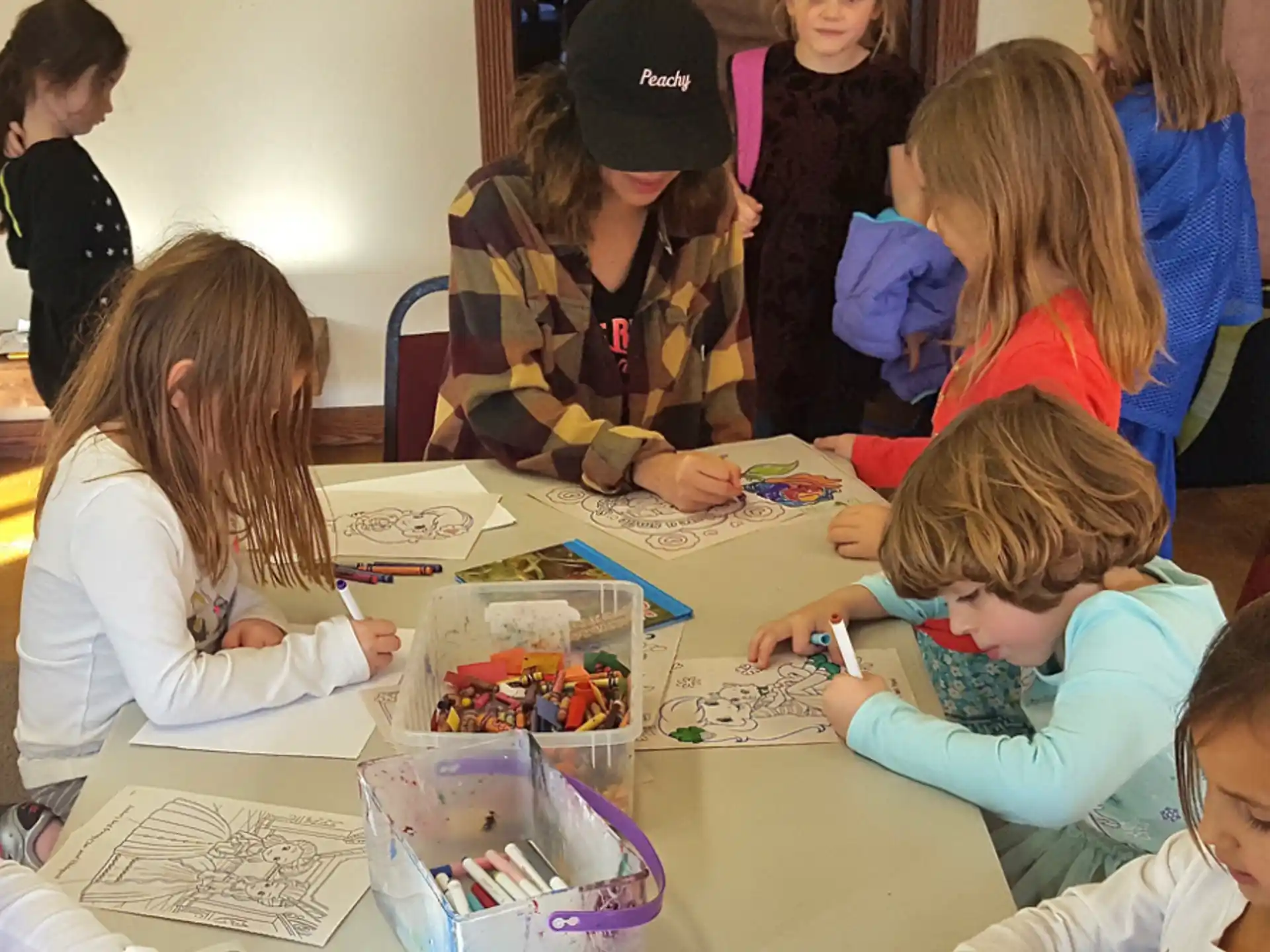 a group of children sitting at a table with a group of people