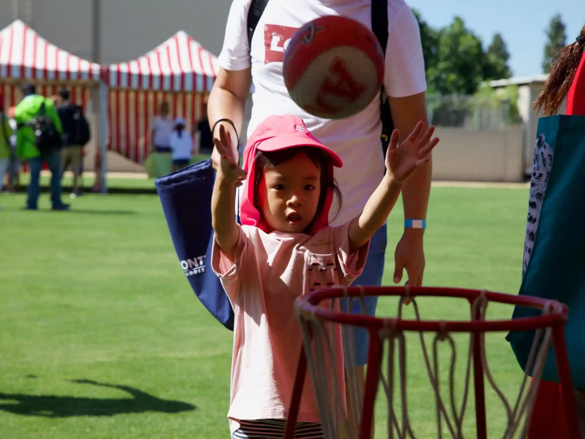 a child in a pink outfit holding a bucket