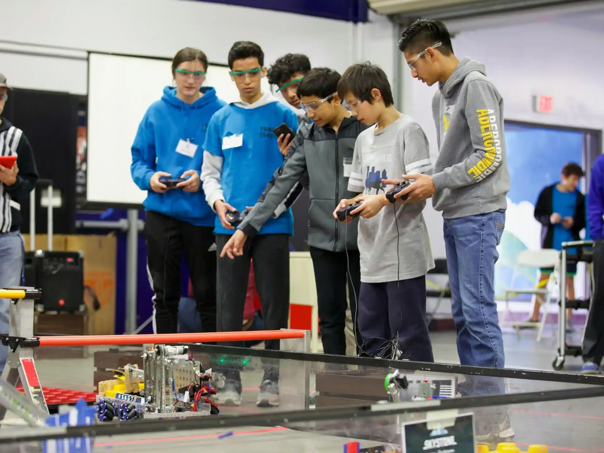 a group of people standing around a table with a game controller