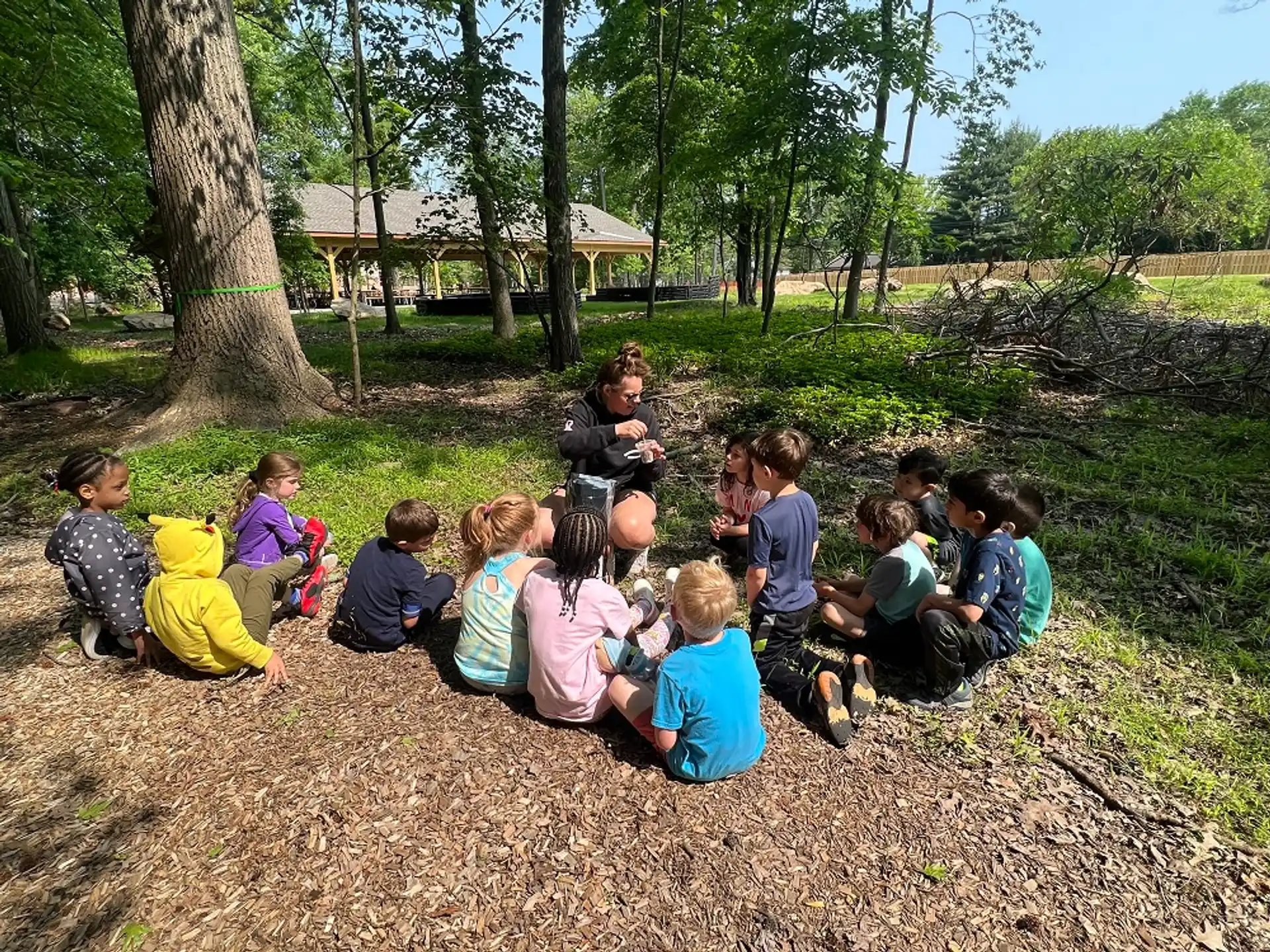 a group of children sitting on the ground outside