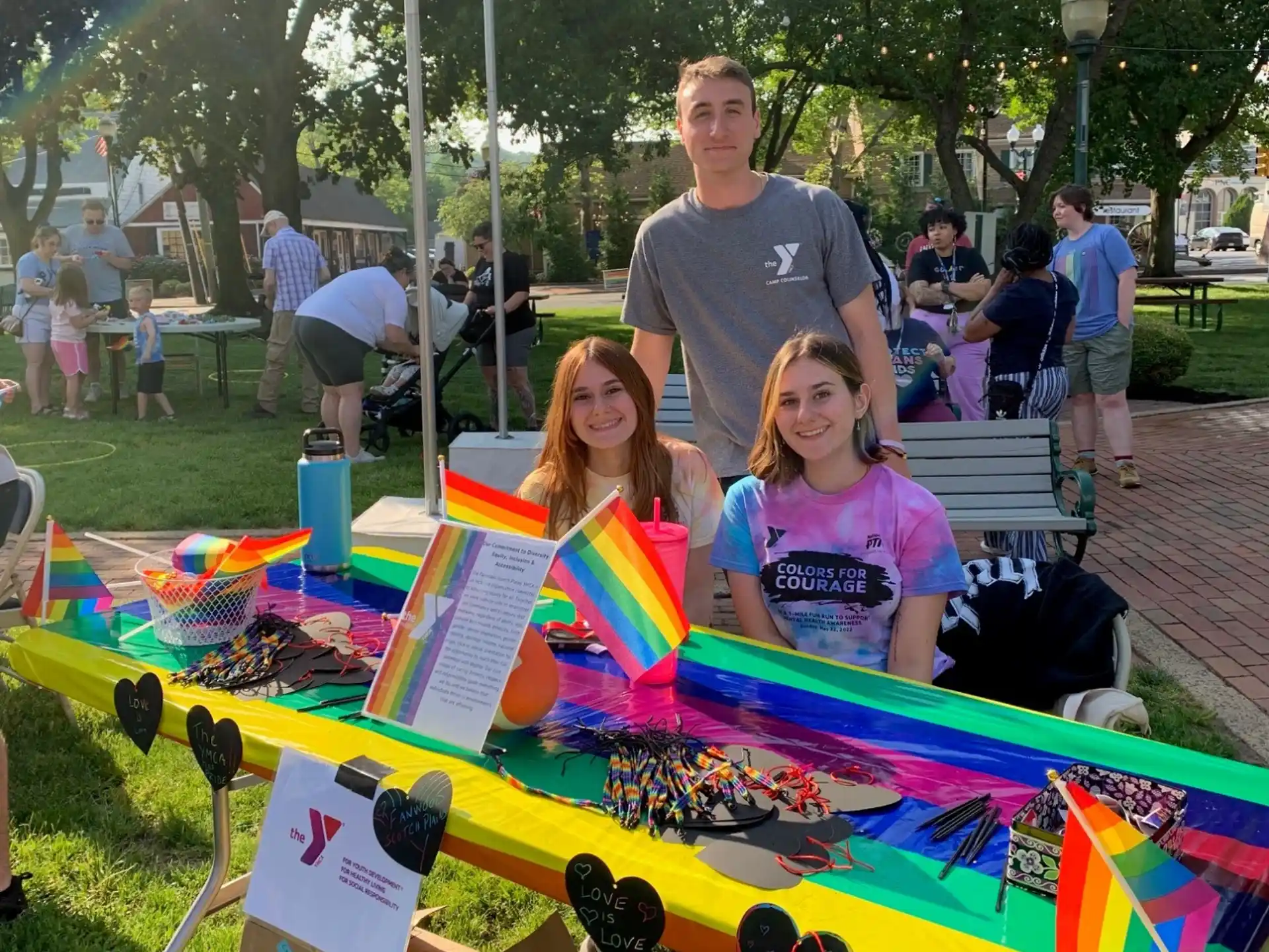 a group of people posing with a large colorful kite