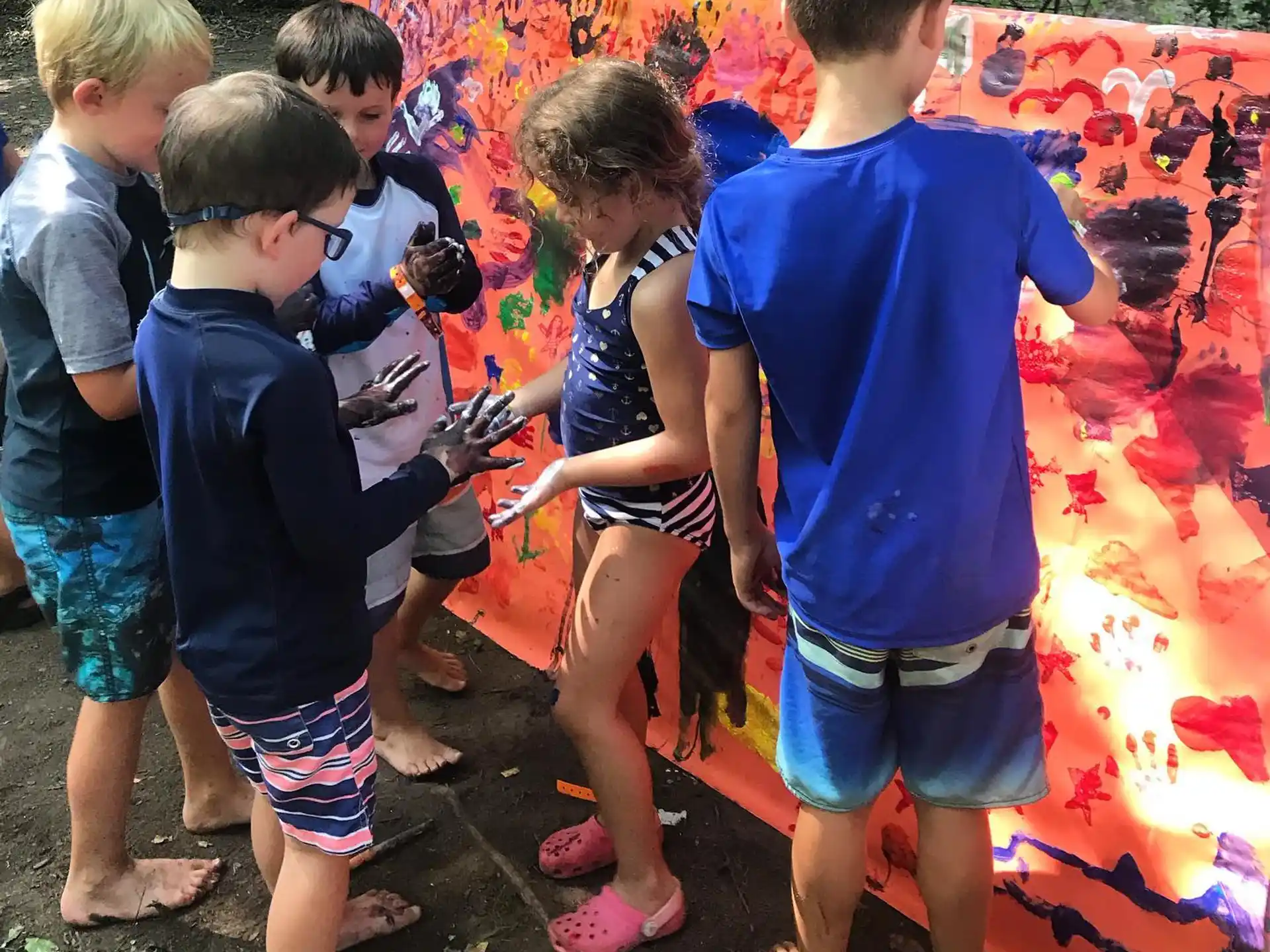 a group of children standing around a flag