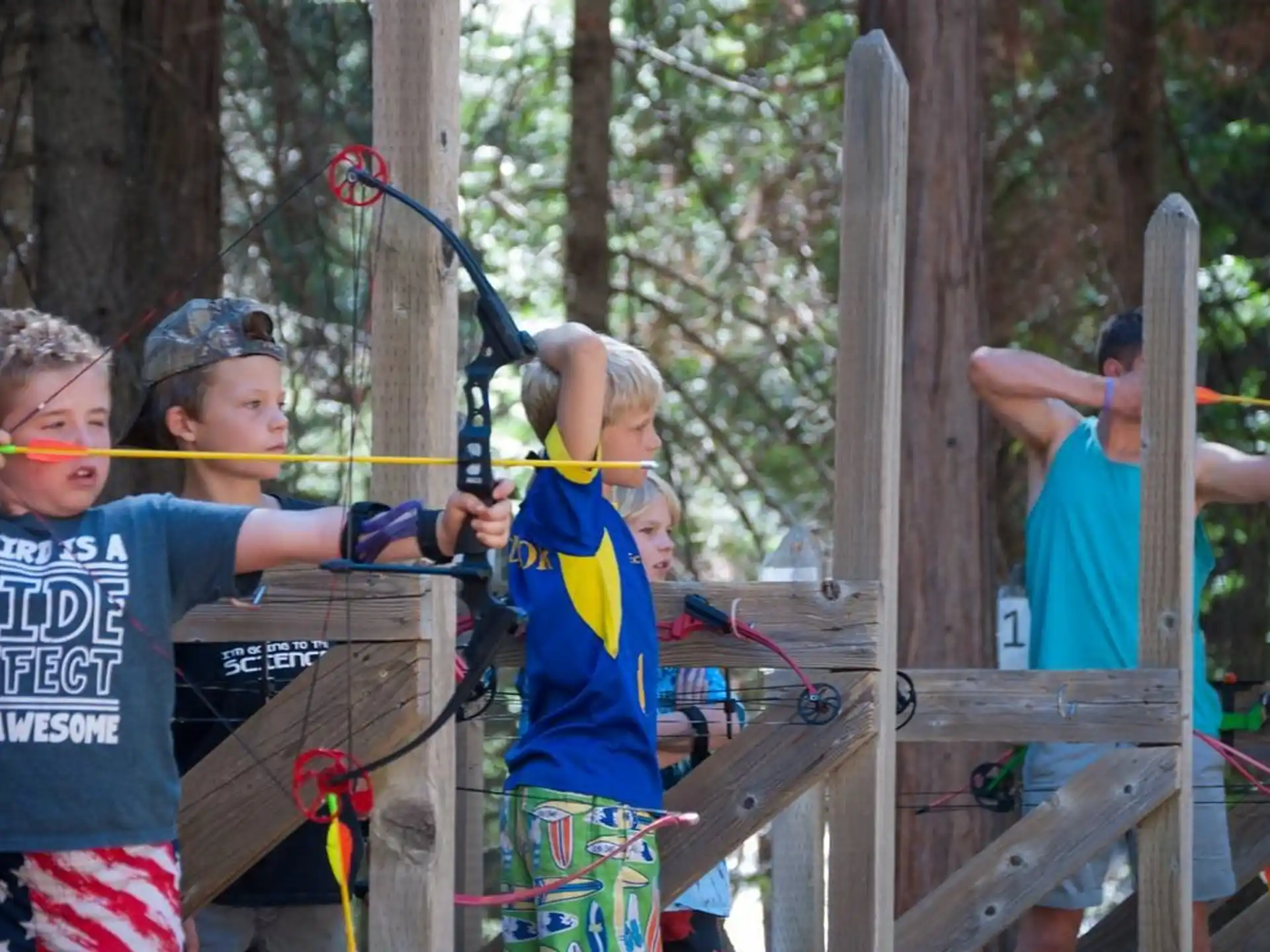 a group of kids playing with bows and arrows