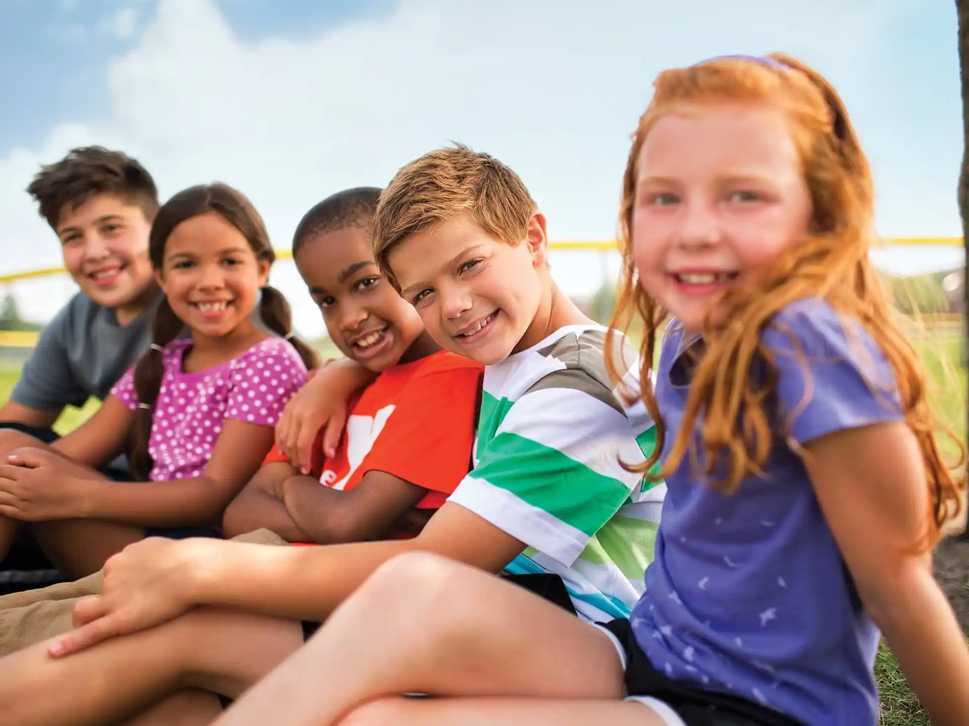 a group of children sitting on the grass