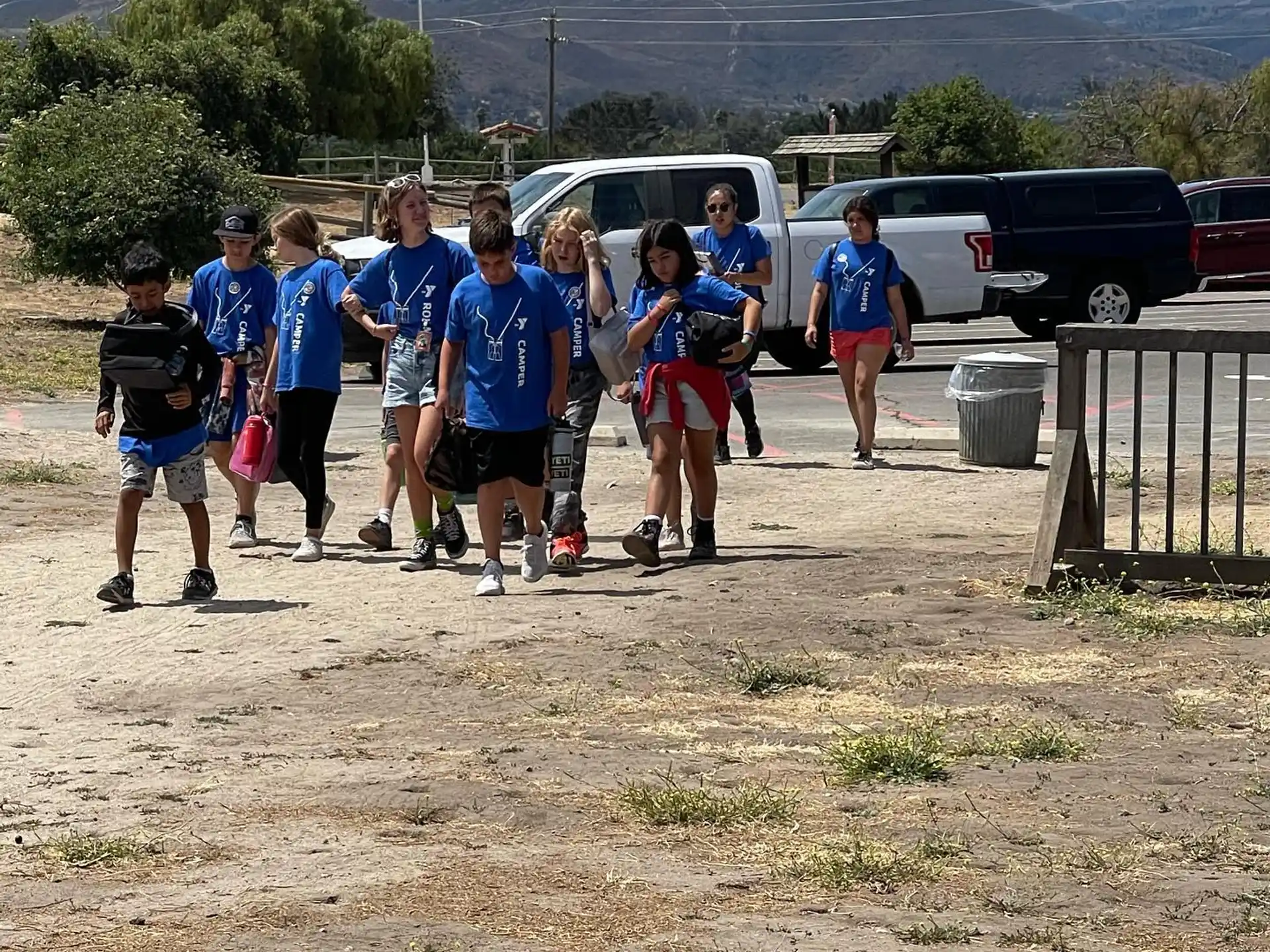 a group of people standing in a line in front of a parking lot