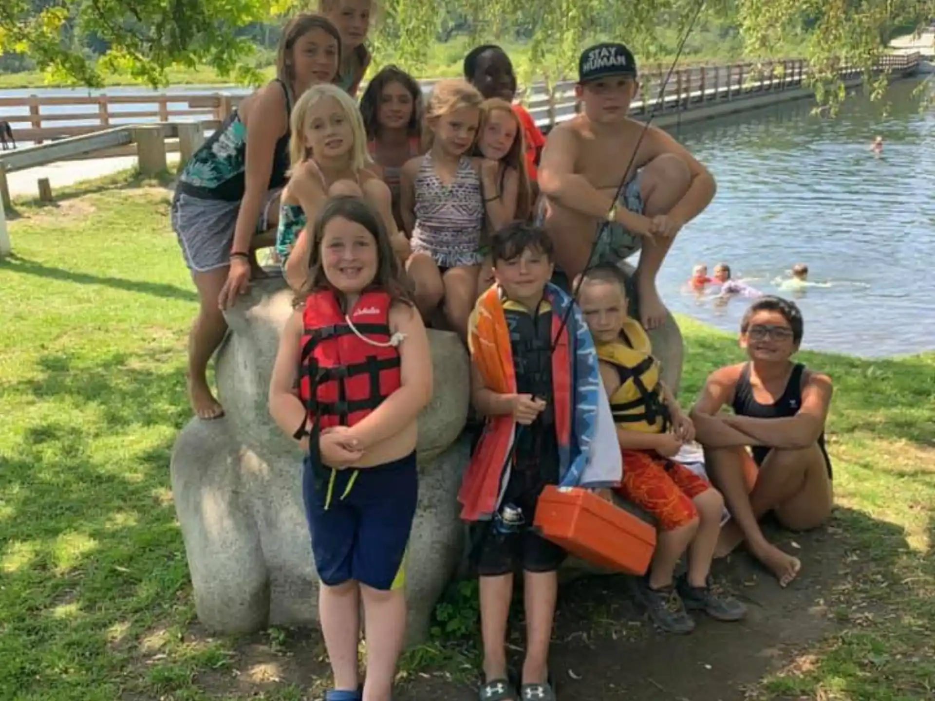 a group of people posing for a photo next to a body of water