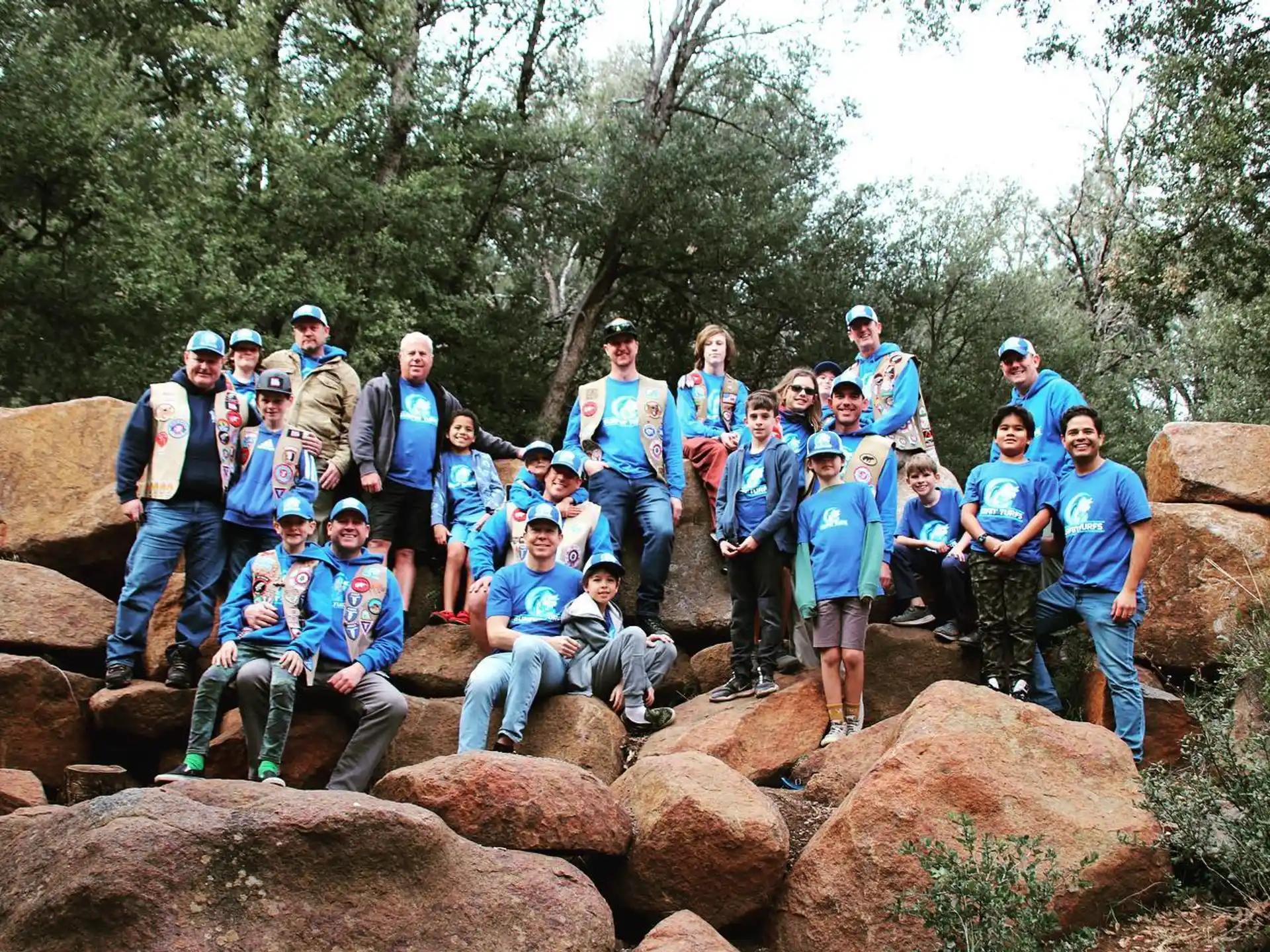 a group of people posing for a photo on some rocks