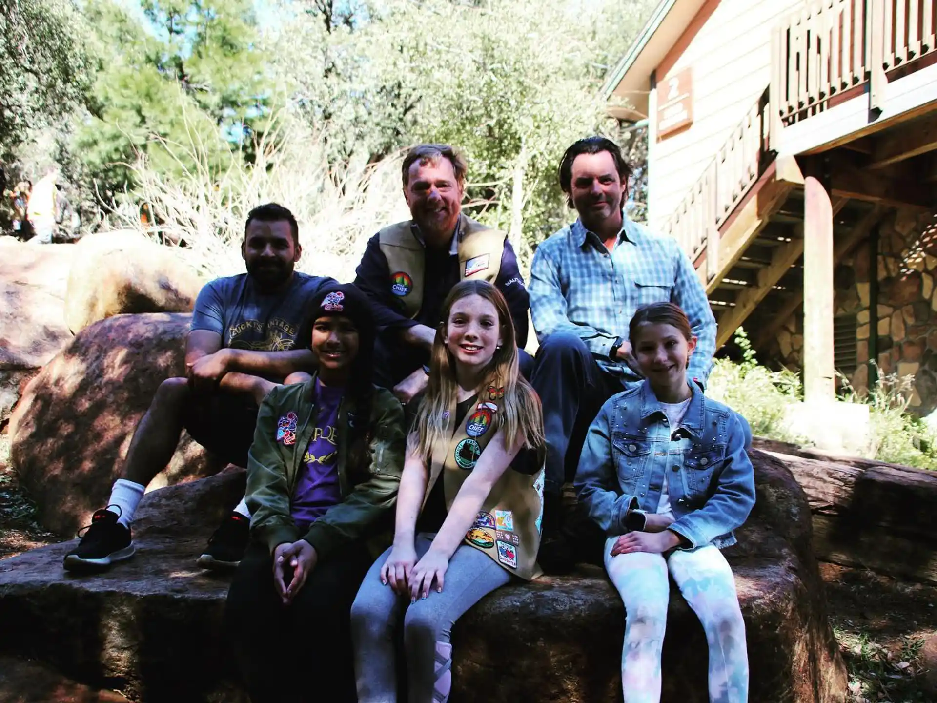 a group of people sitting on a rock posing for the camera