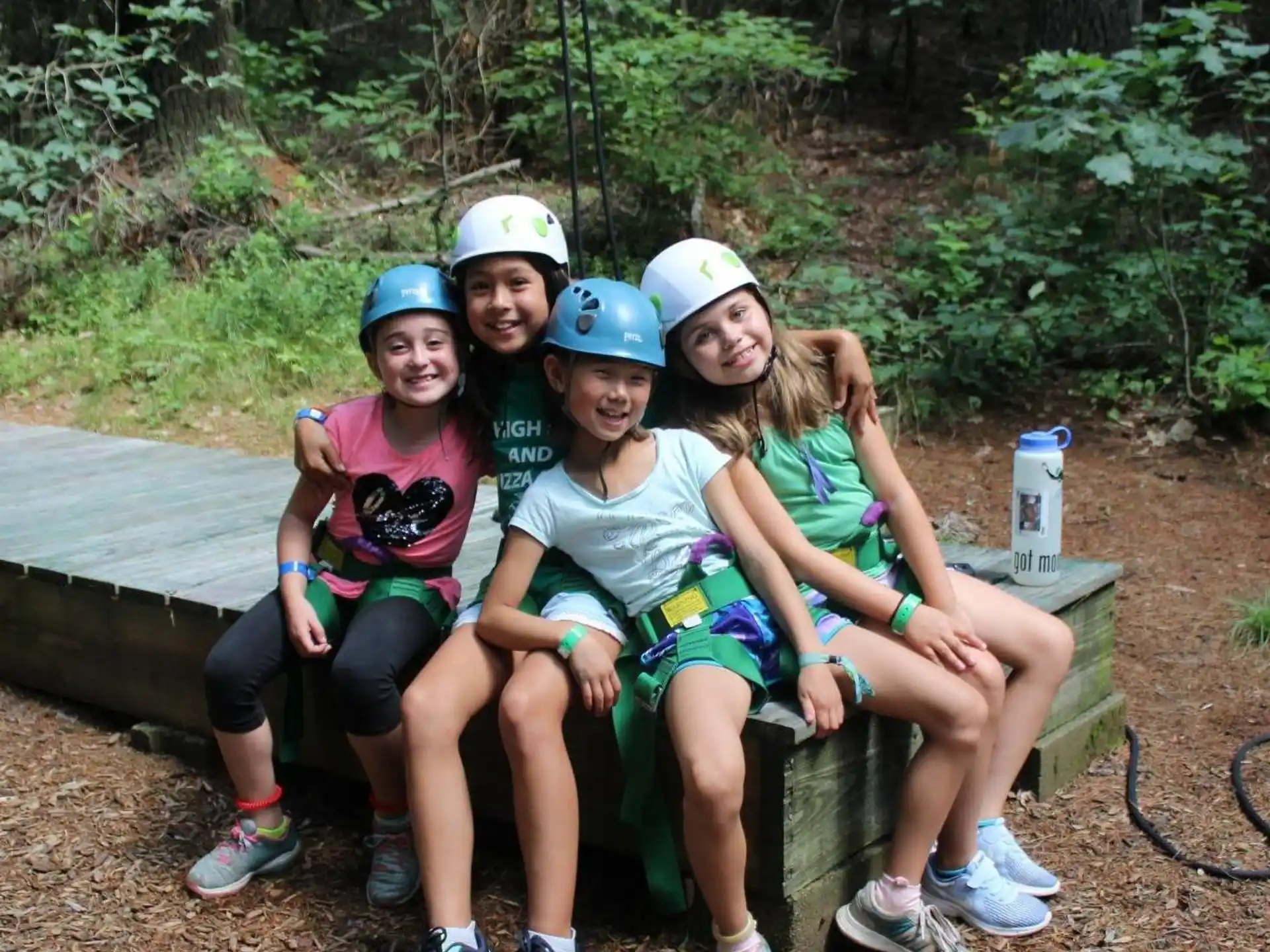 a group of people wearing helmets and sitting on a bench