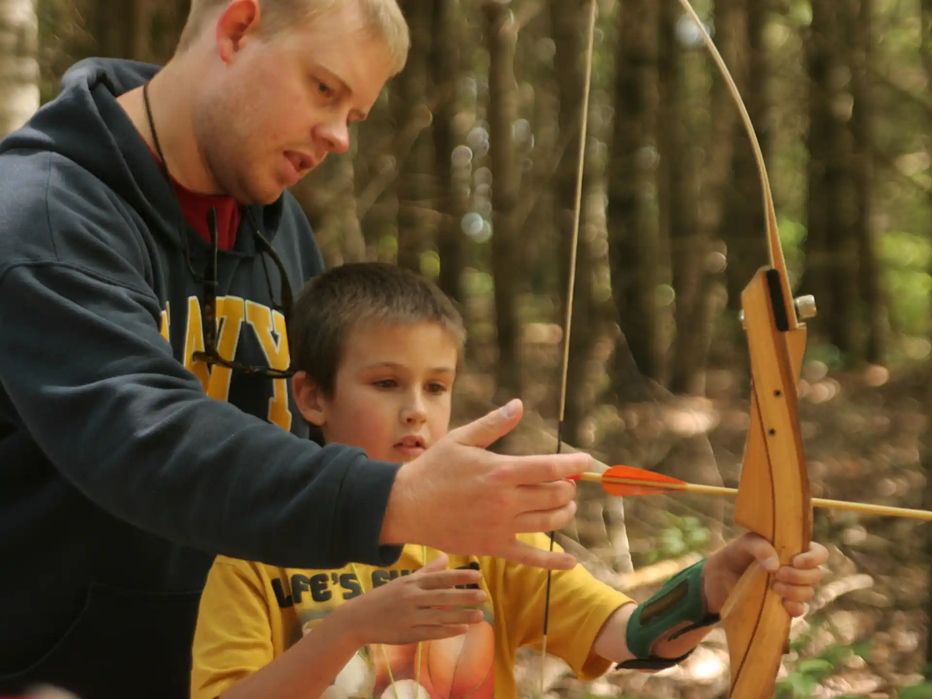 a person and a boy holding a bow and arrow