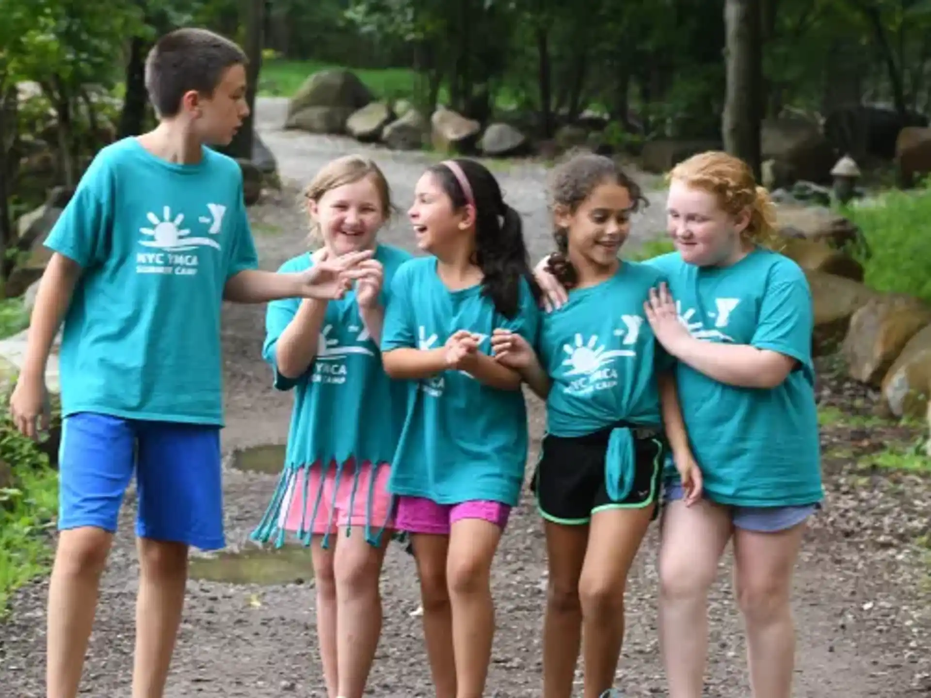 a group of children standing on a path in the woods