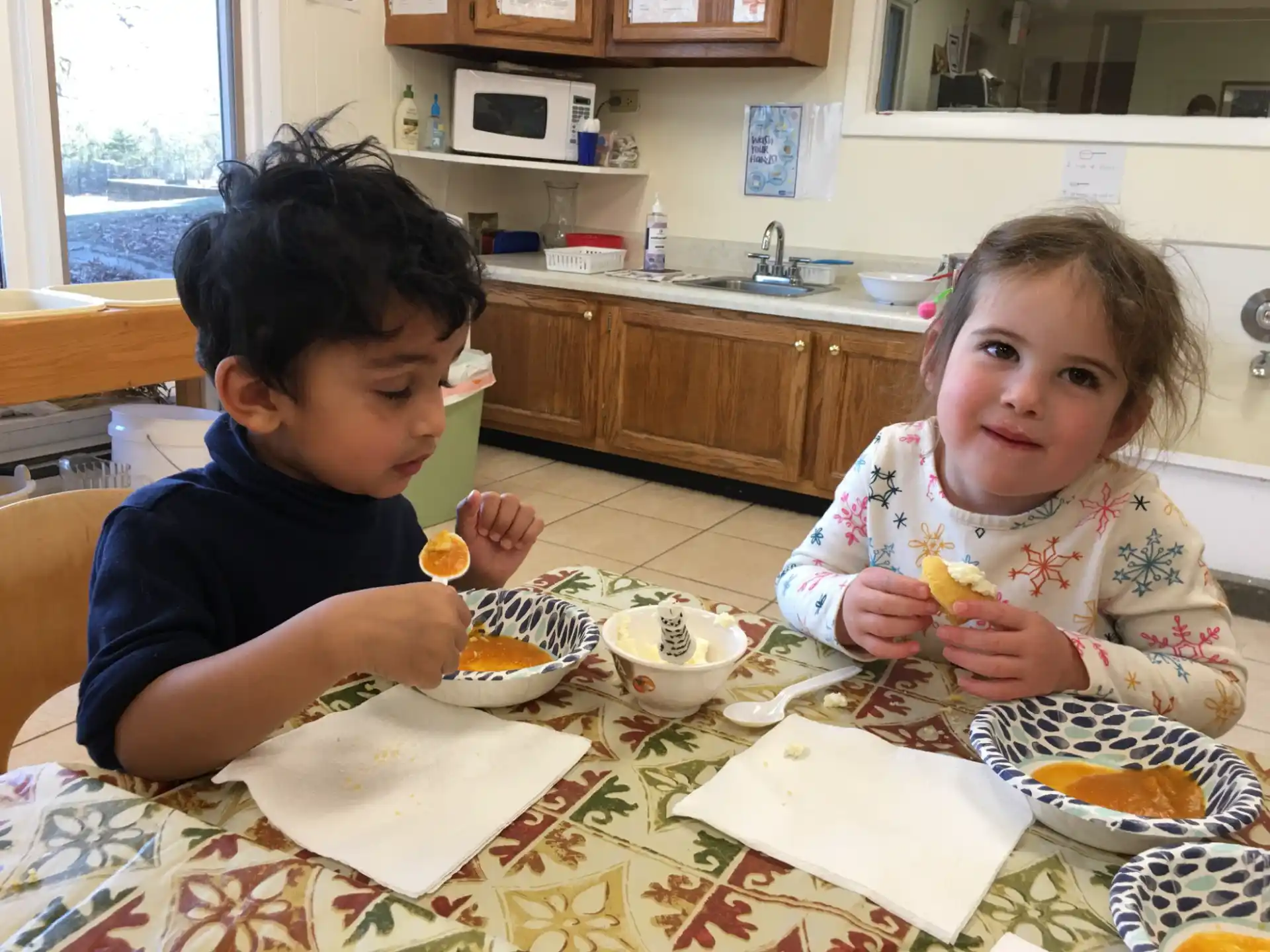 a couple of kids eating at a table