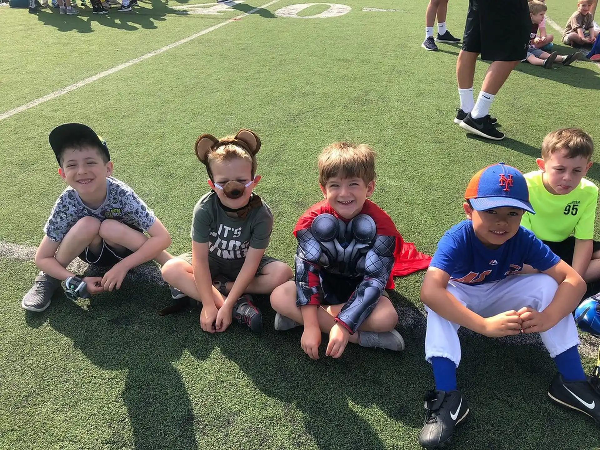 a group of kids sitting on the grass