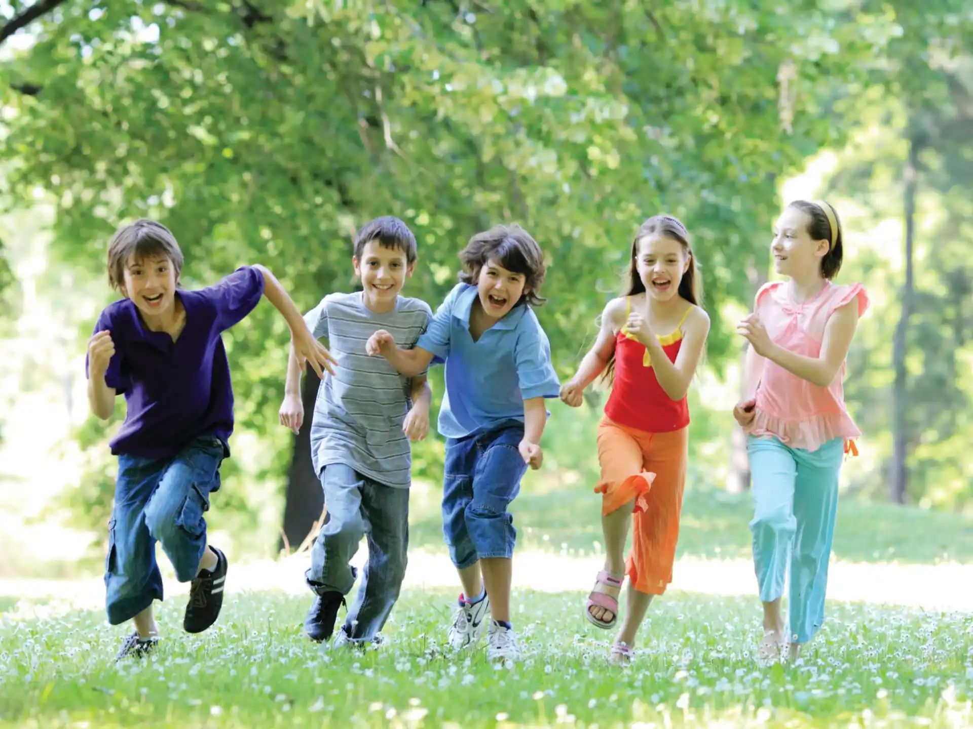 a group of children running in a park